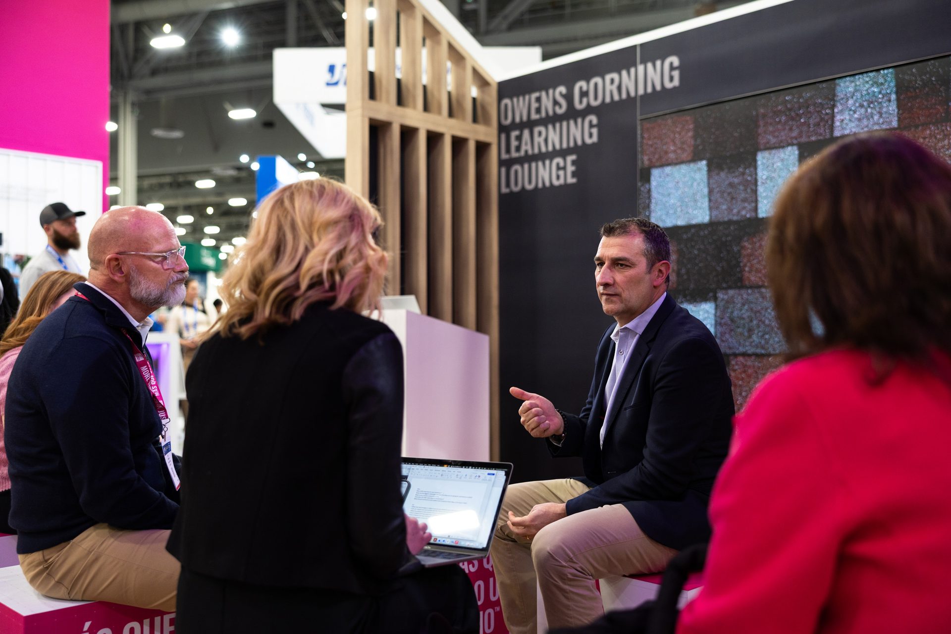 Group of people discussing in a learning lounge at a trade show or event.