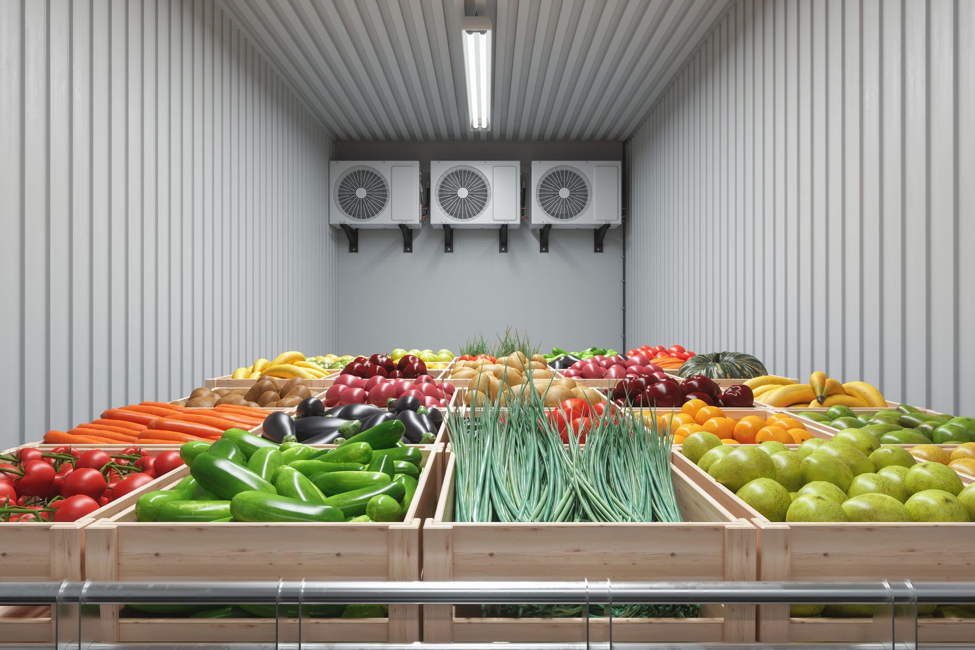 Fresh produce in wooden crates inside a walk-in cooler with three wall-mounted cooling units.