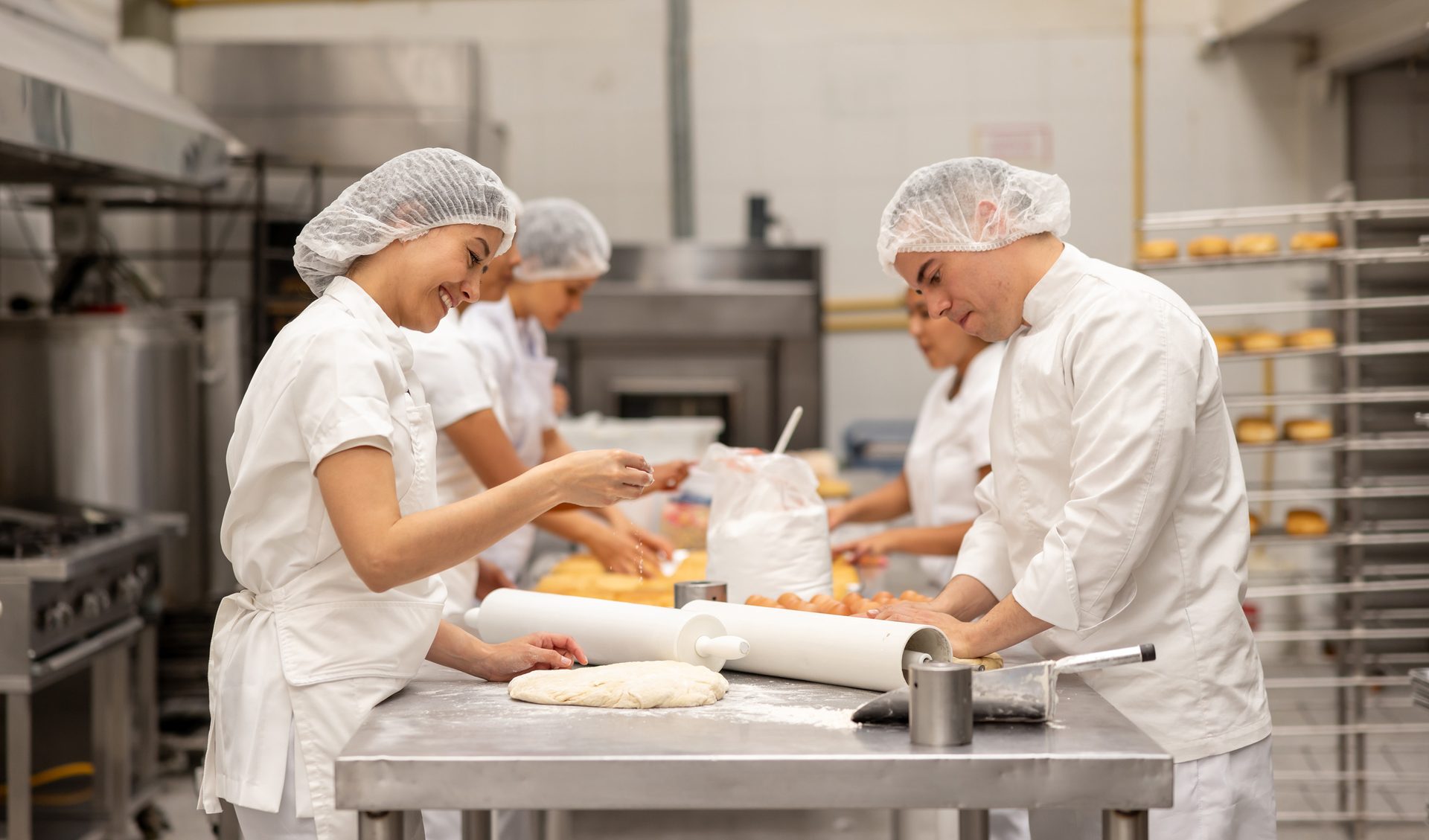 Bakers making dough in a commercial kitchen.