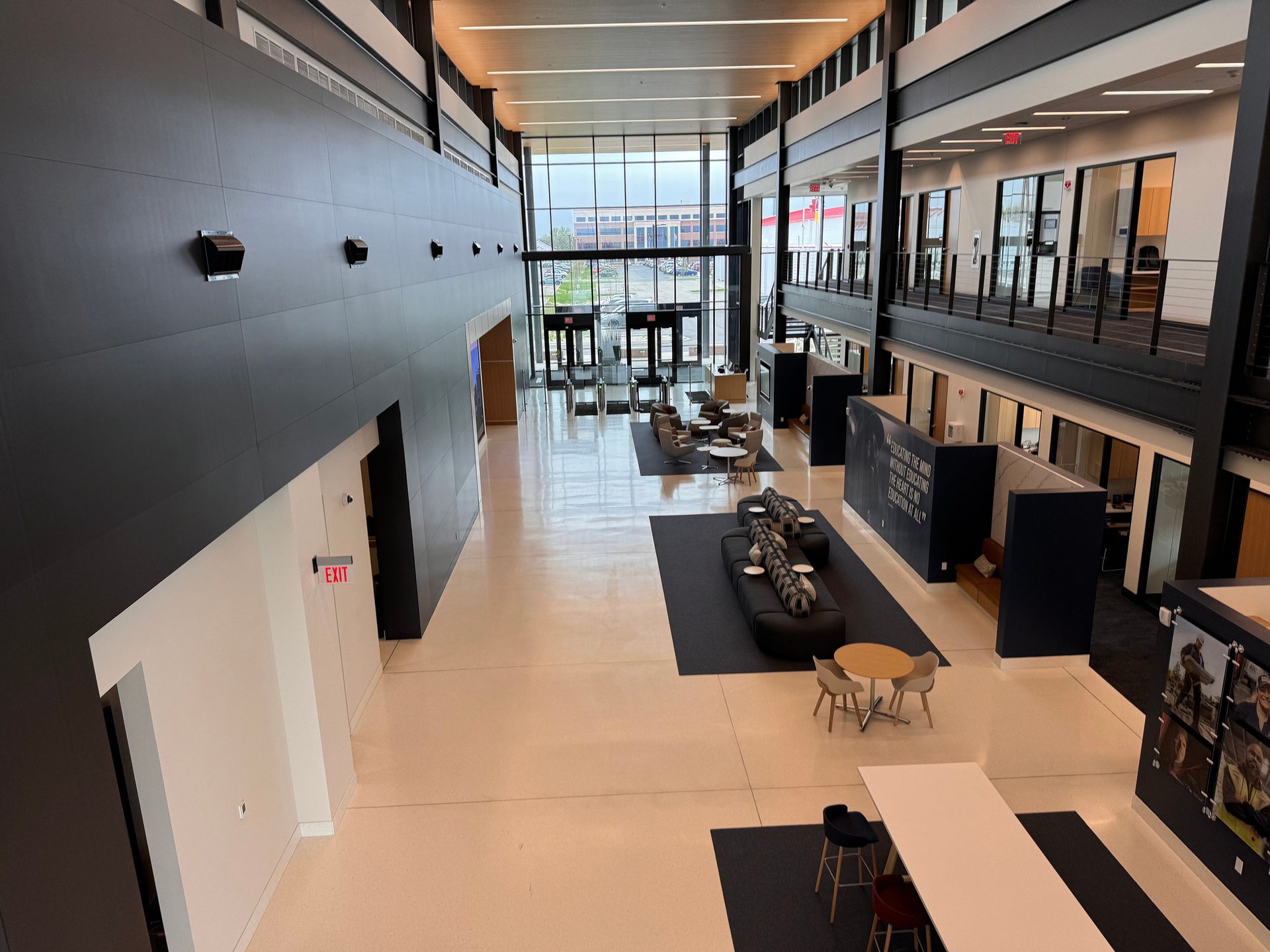 Bright, modern multi-level building lobby with lounge areas and large windows.