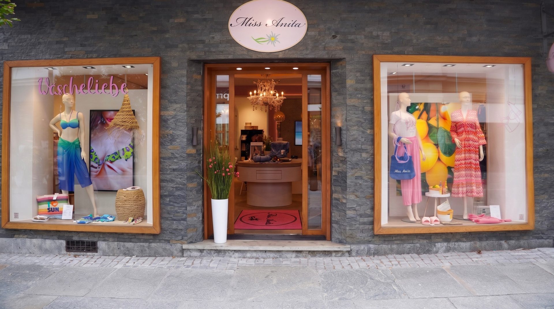 Miss Anita boutique storefront with display windows showing swimwear and dresses, and open entrance.
