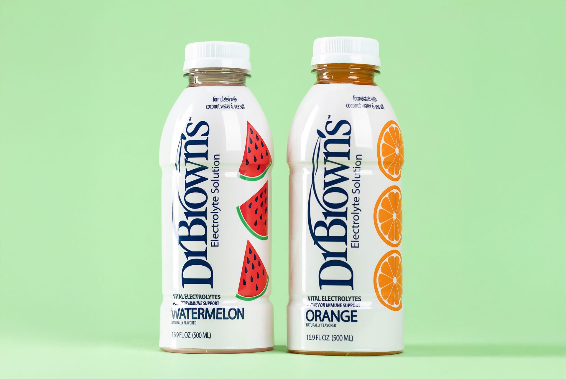Two bottles of Dr. Brown's Electrolyte Solution, watermelon and orange flavors, on a green background.