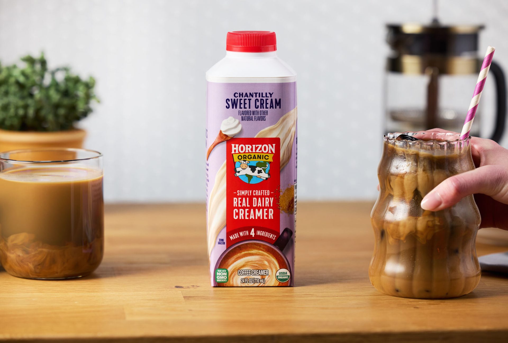 Horizon Organic Chantilly Sweet Cream creamer between two coffee glasses on a wooden table.