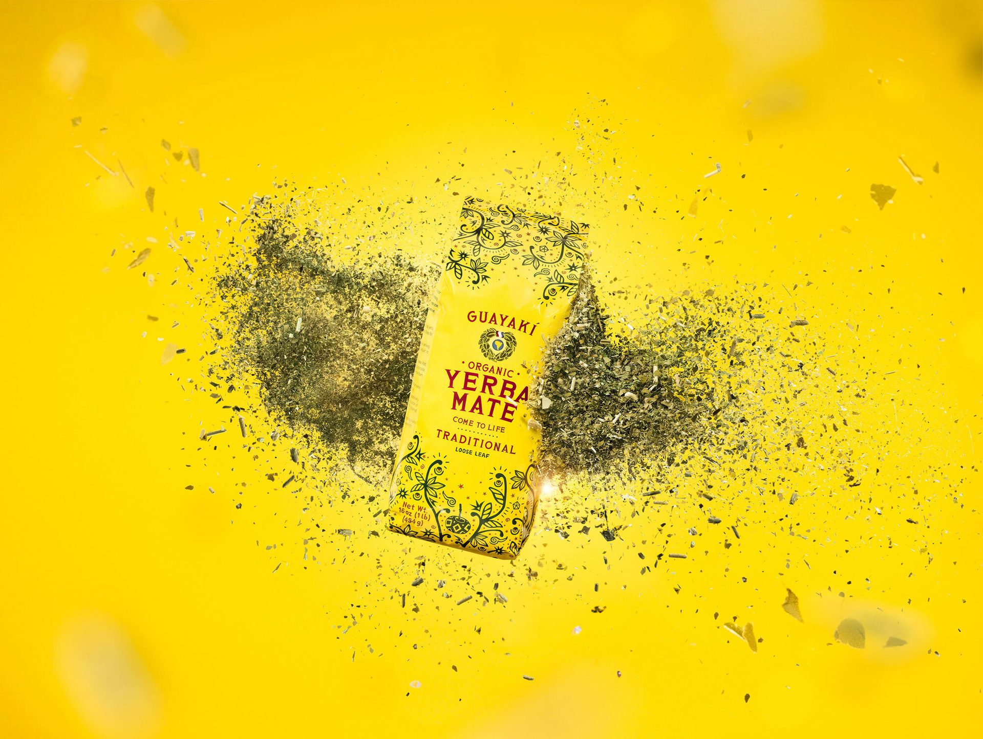 Guayaki Yerba Mate loose leaf package on bright yellow background with scattered tea leaves.