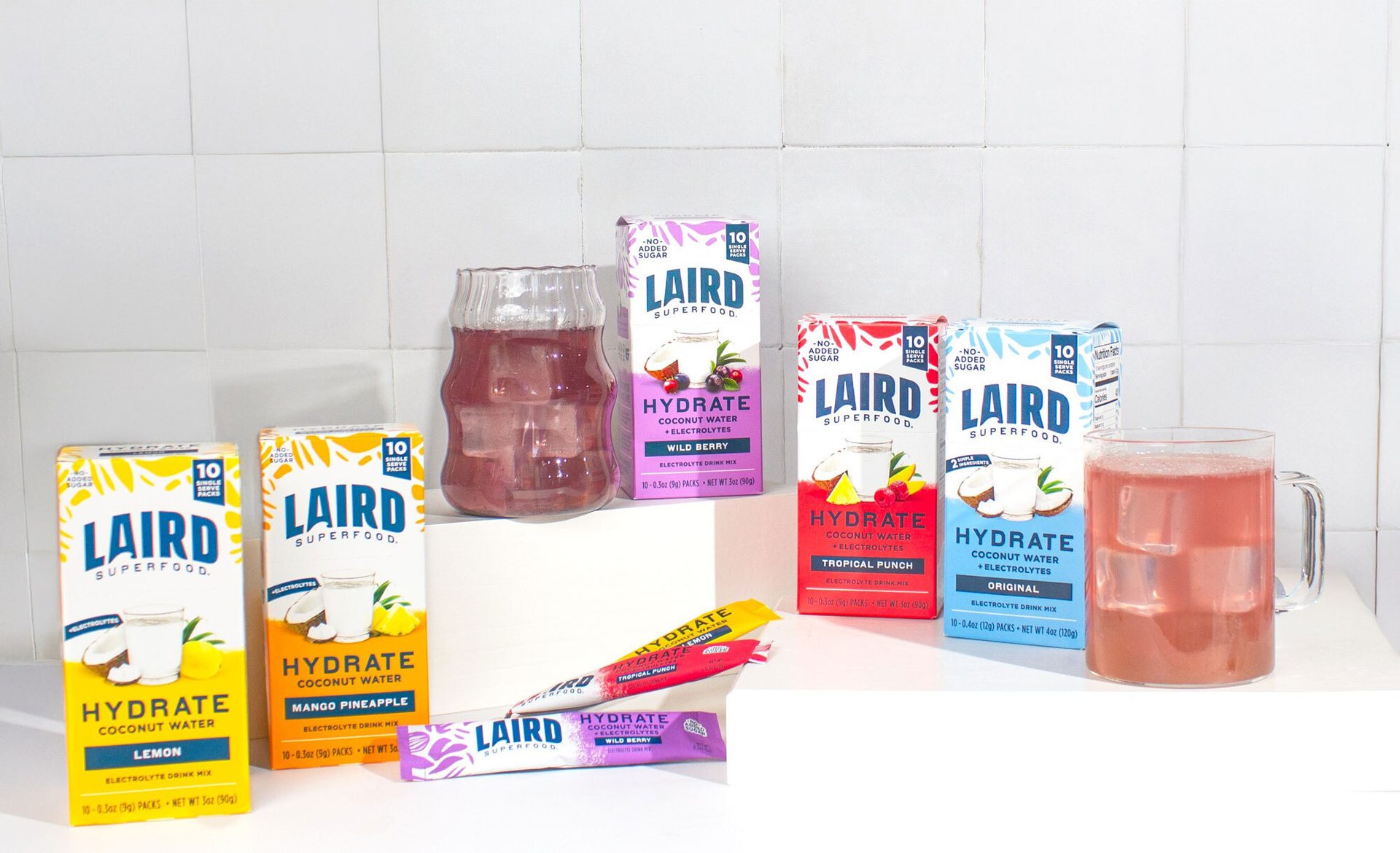 Various flavors of Laird Superfood Hydrate coconut water electrolyte drink mixes and prepared drinks.