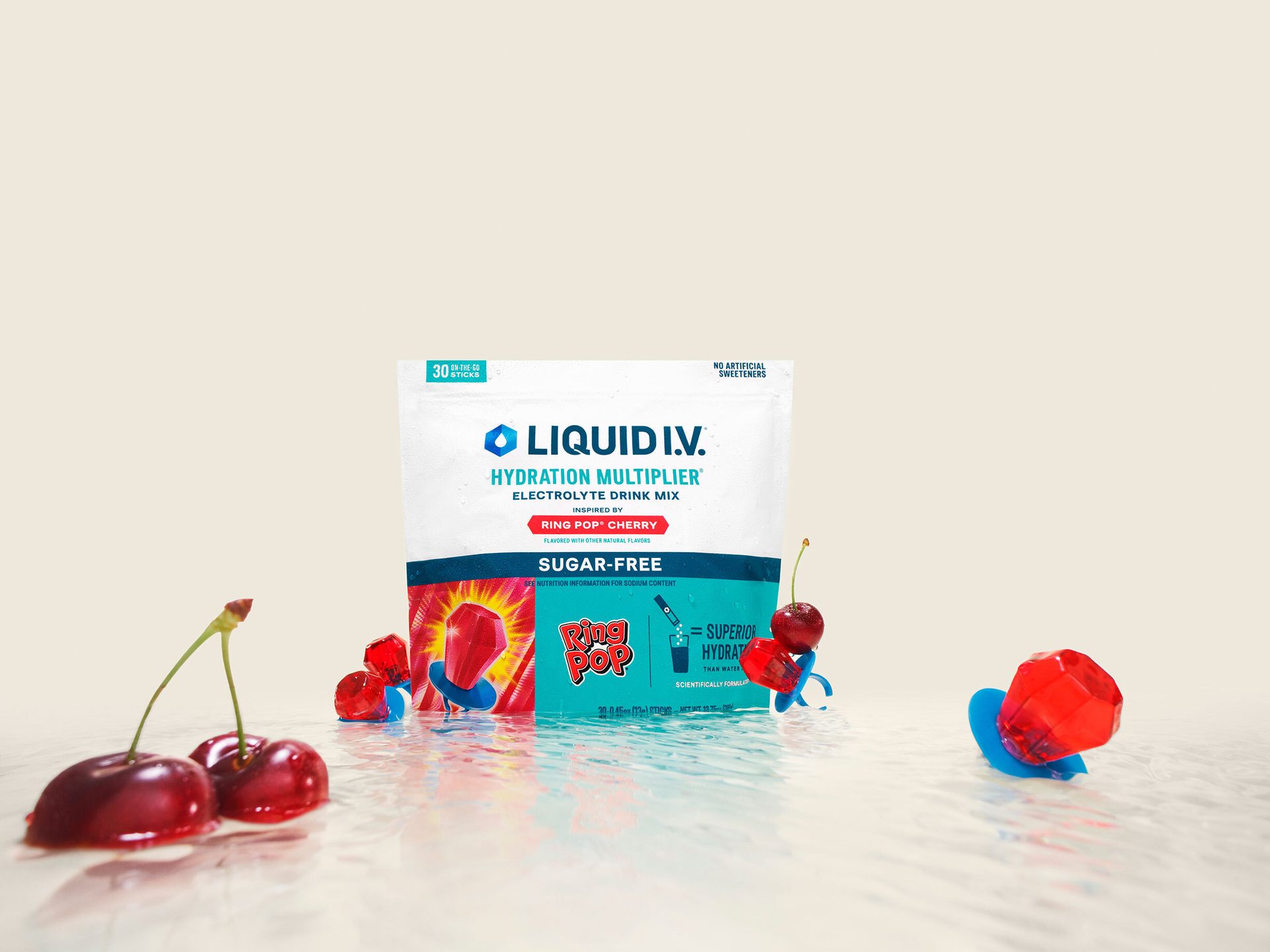 Liquid I.V. sugar-free Ring Pop Cherry hydration mix, with cherries and candies on a wet surface.