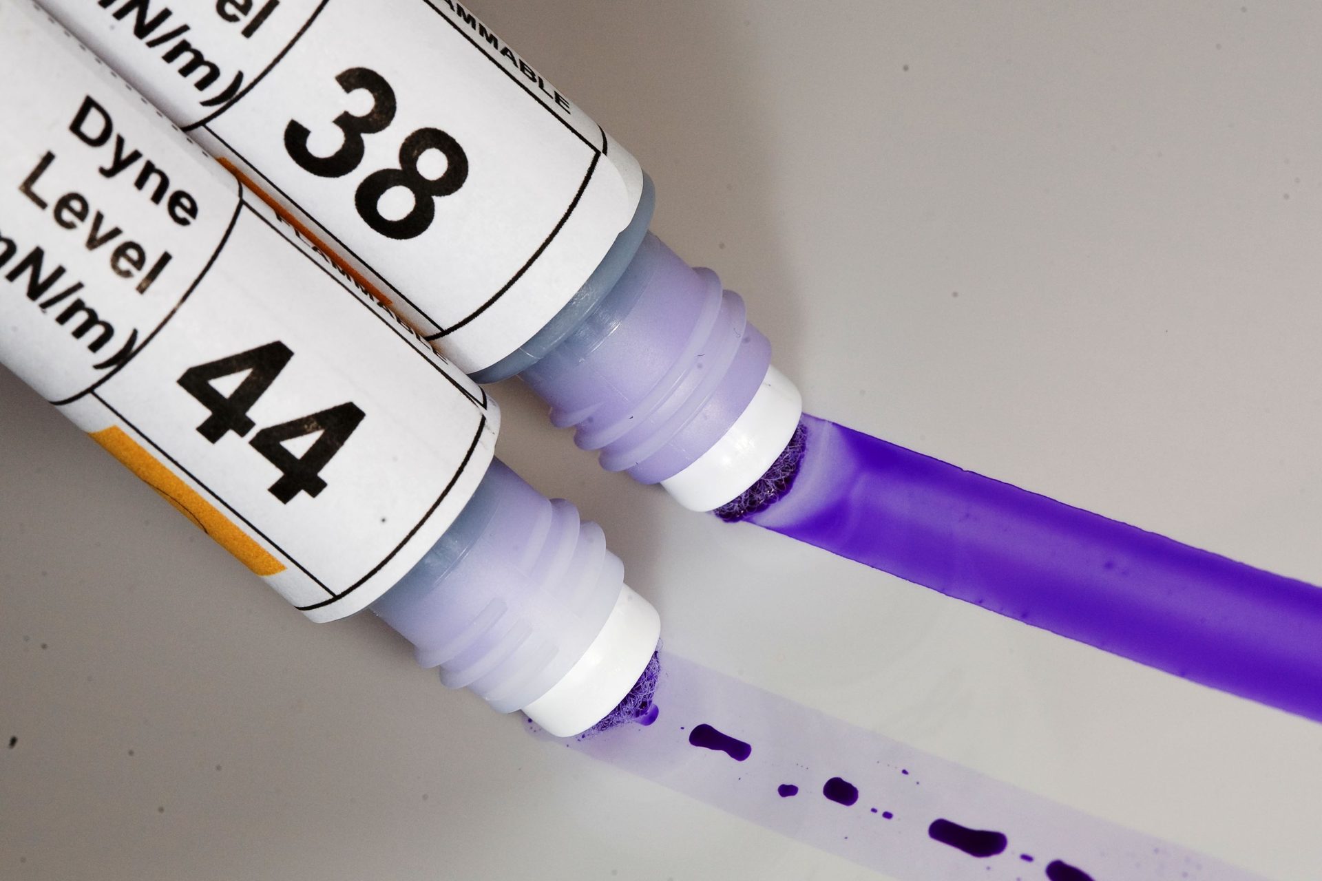 Two dyne level test pens, labeled 44 and 38, leaving solid and broken purple lines.