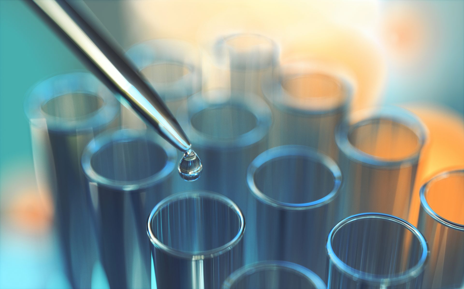 A close-up of a pipette releasing a clear drop into a test tube, symbolizing scientific research.