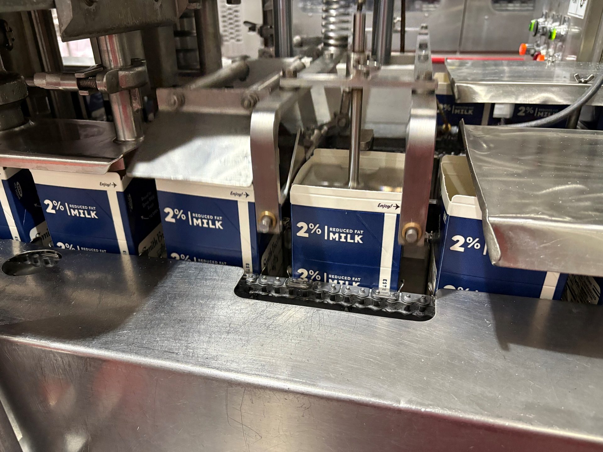 2% reduced fat milk cartons on a factory packaging line conveyor belt.