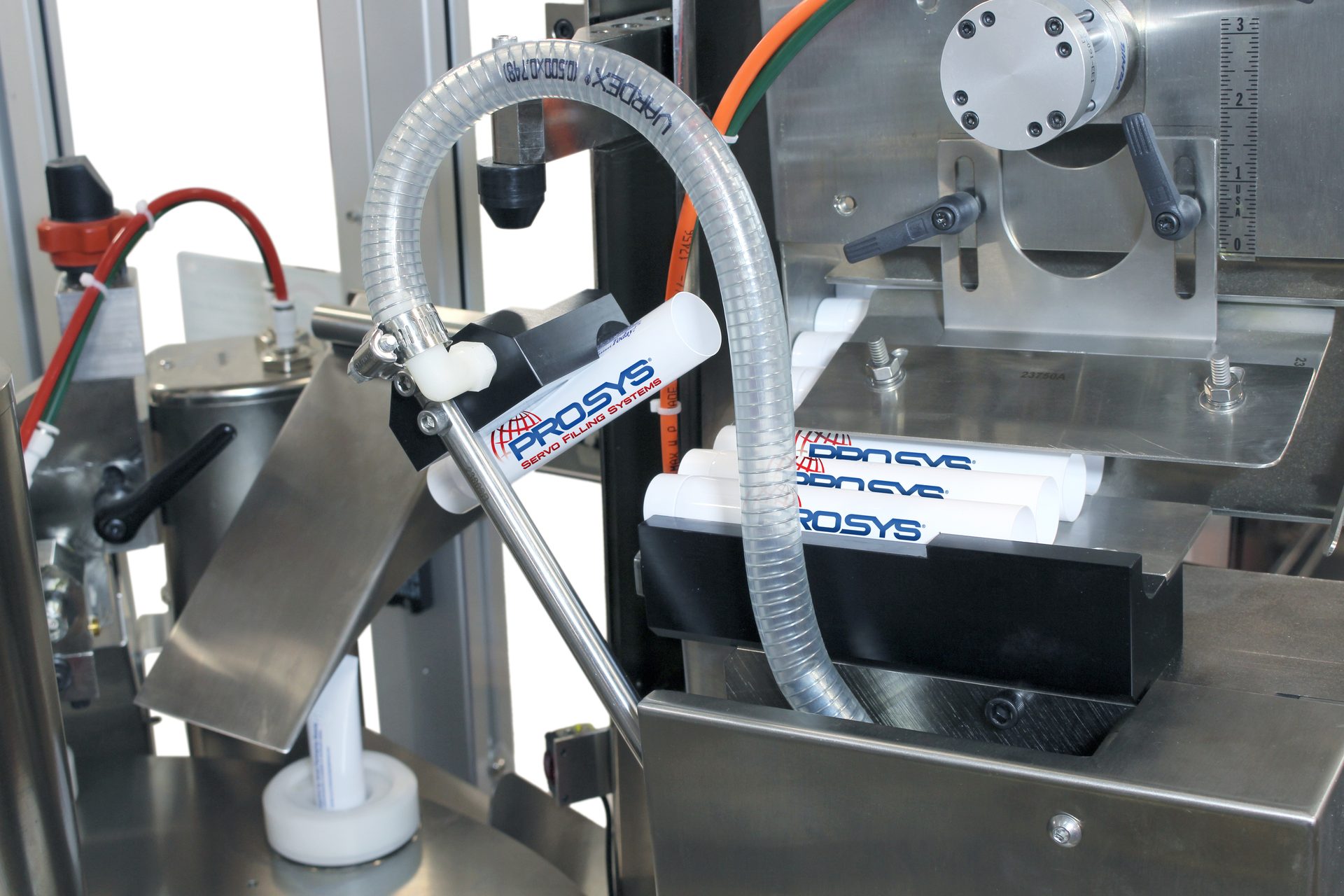Industrial tube filling machine with white PROSYS tubes, clear hoses, and metal parts.