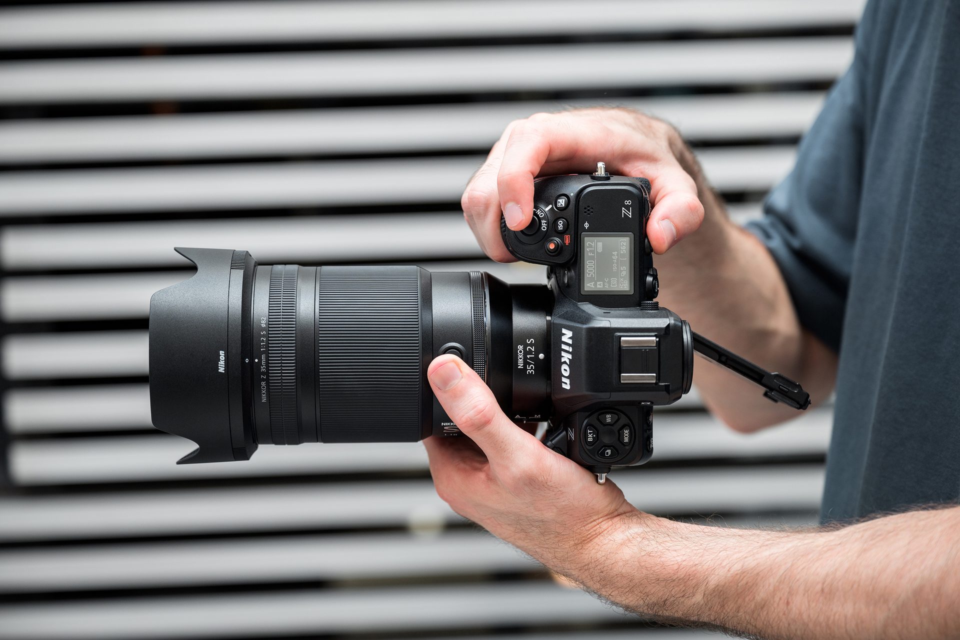 Person holds Nikon Z8 camera with Nikkor Z 35mm f/1.2 S lens, top display visible.