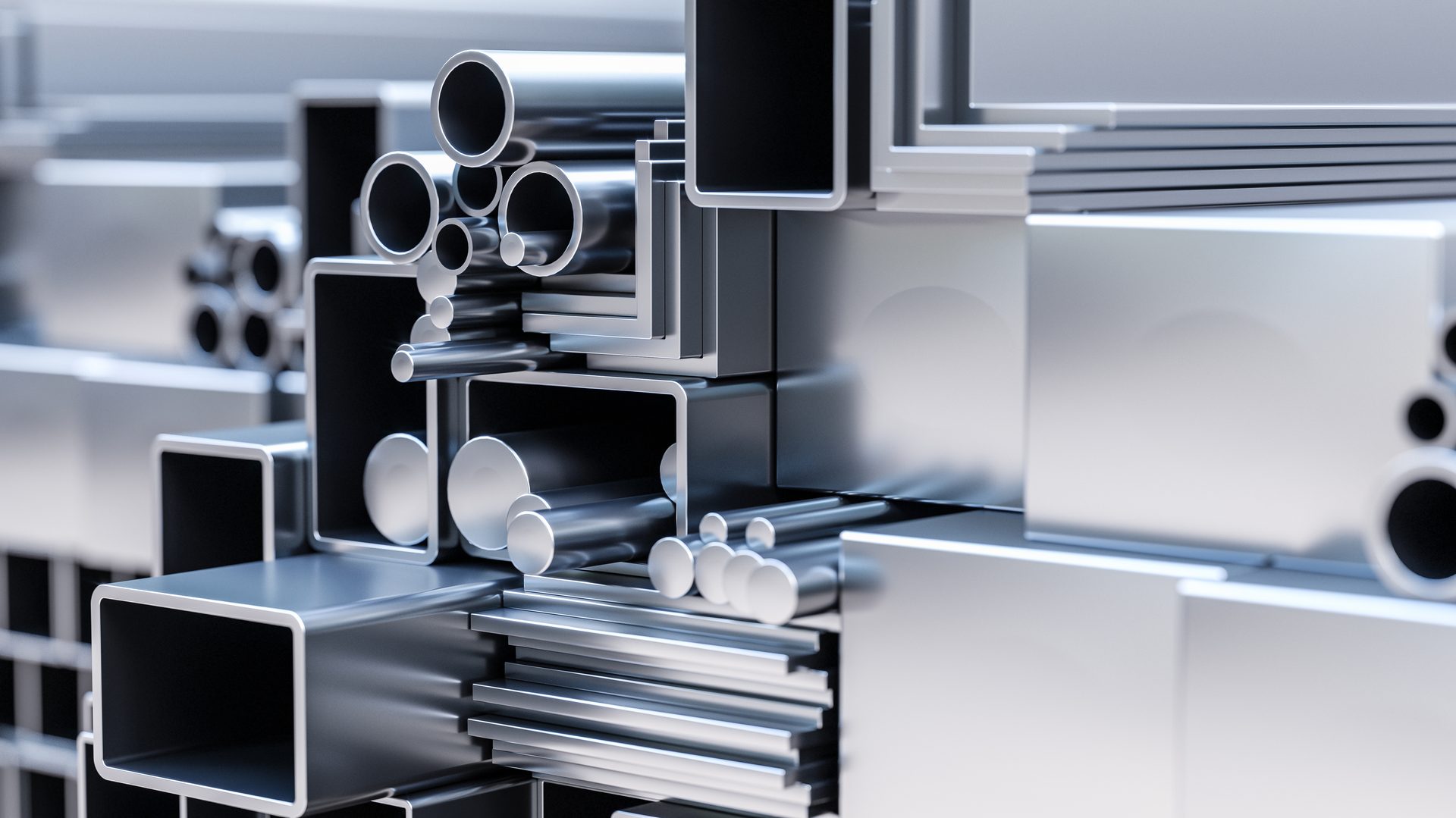 Assortment of shiny metal industrial profiles: tubes, pipes, rods, and angles.