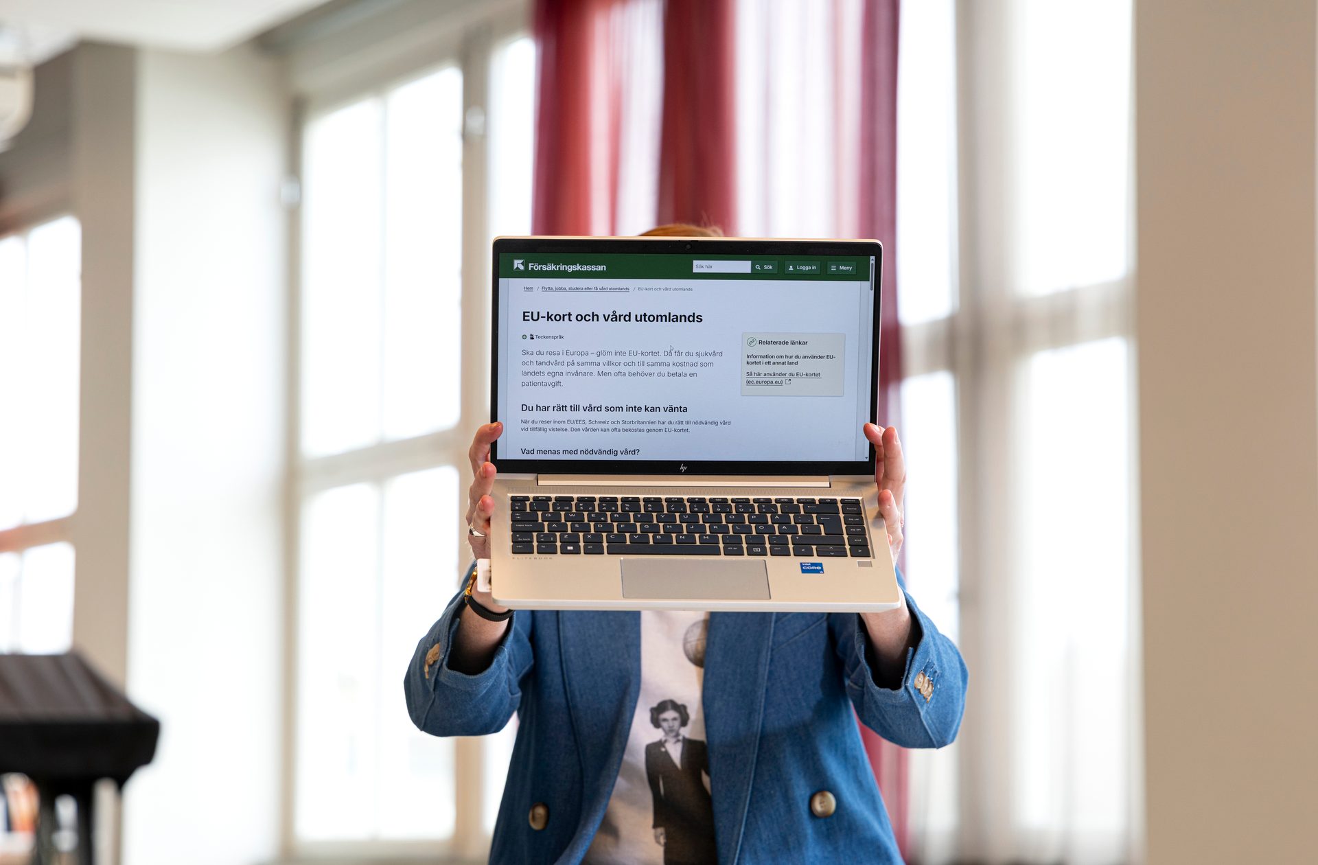 Hands hold a laptop displaying the Försäkringskassan website about EU health cards and healthcare abroad.
