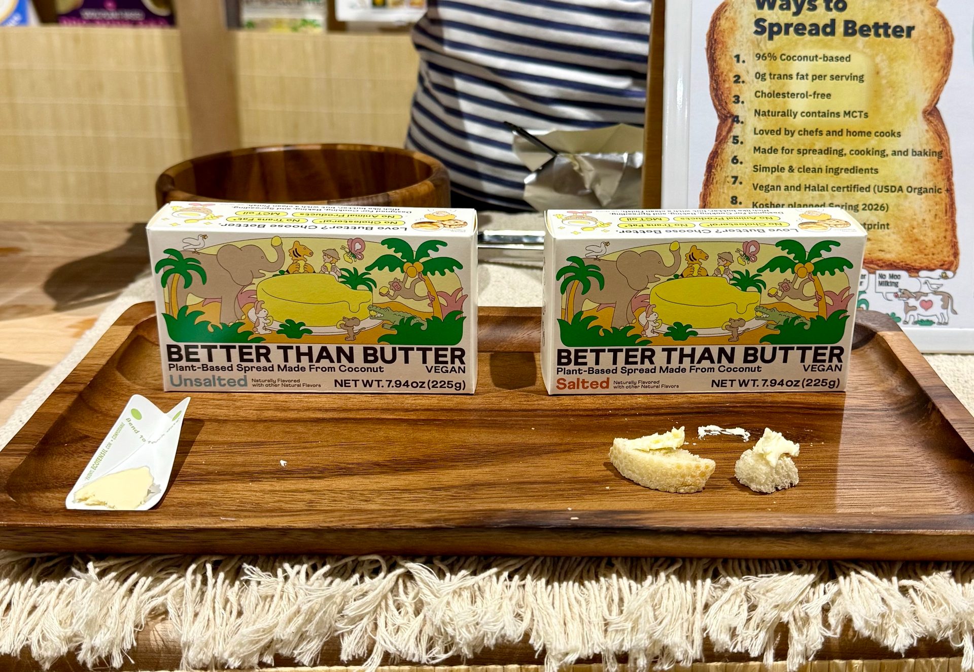 Two boxes of "Better Than Butter" plant-based spread (unsalted and salted) with samples on a wooden tray.