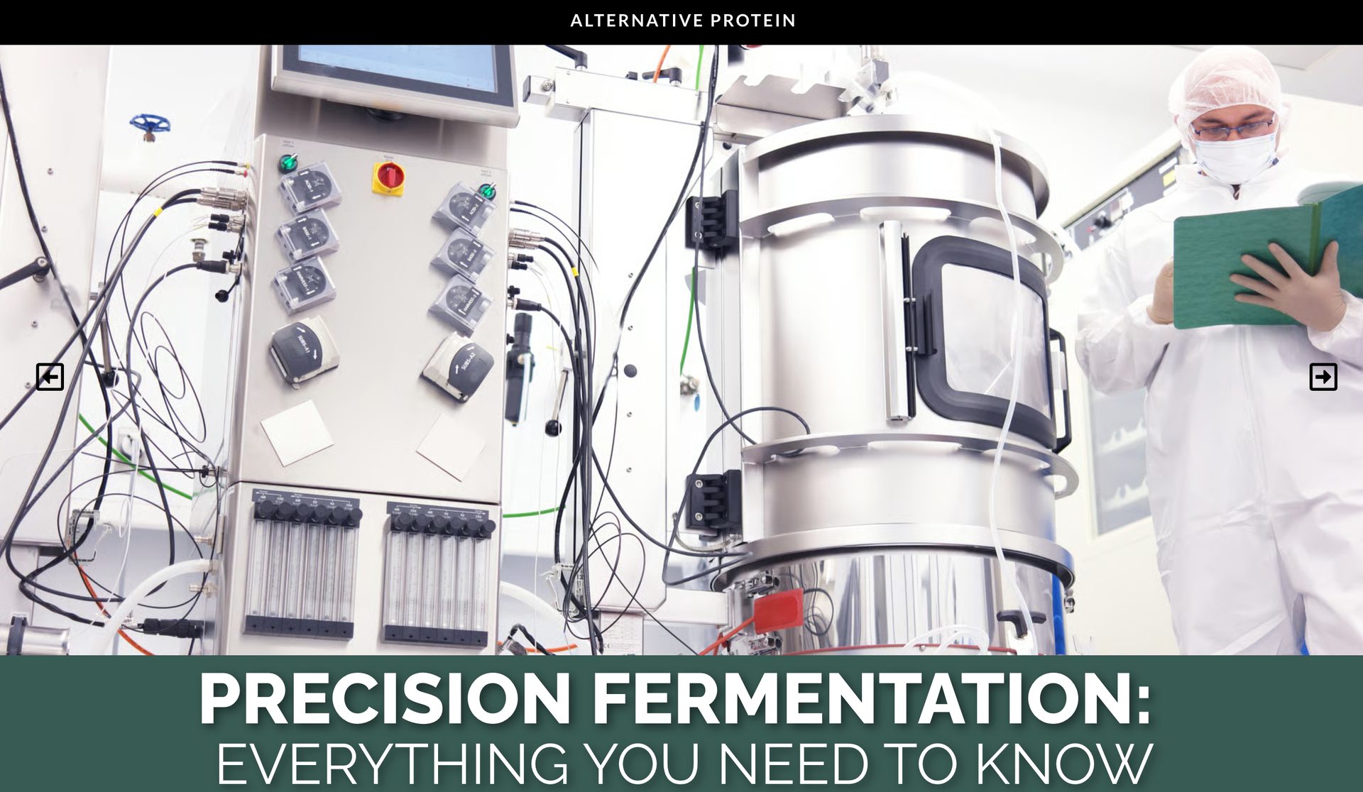 Scientist in cleanroom with bioreactor and control panel for alternative protein research.