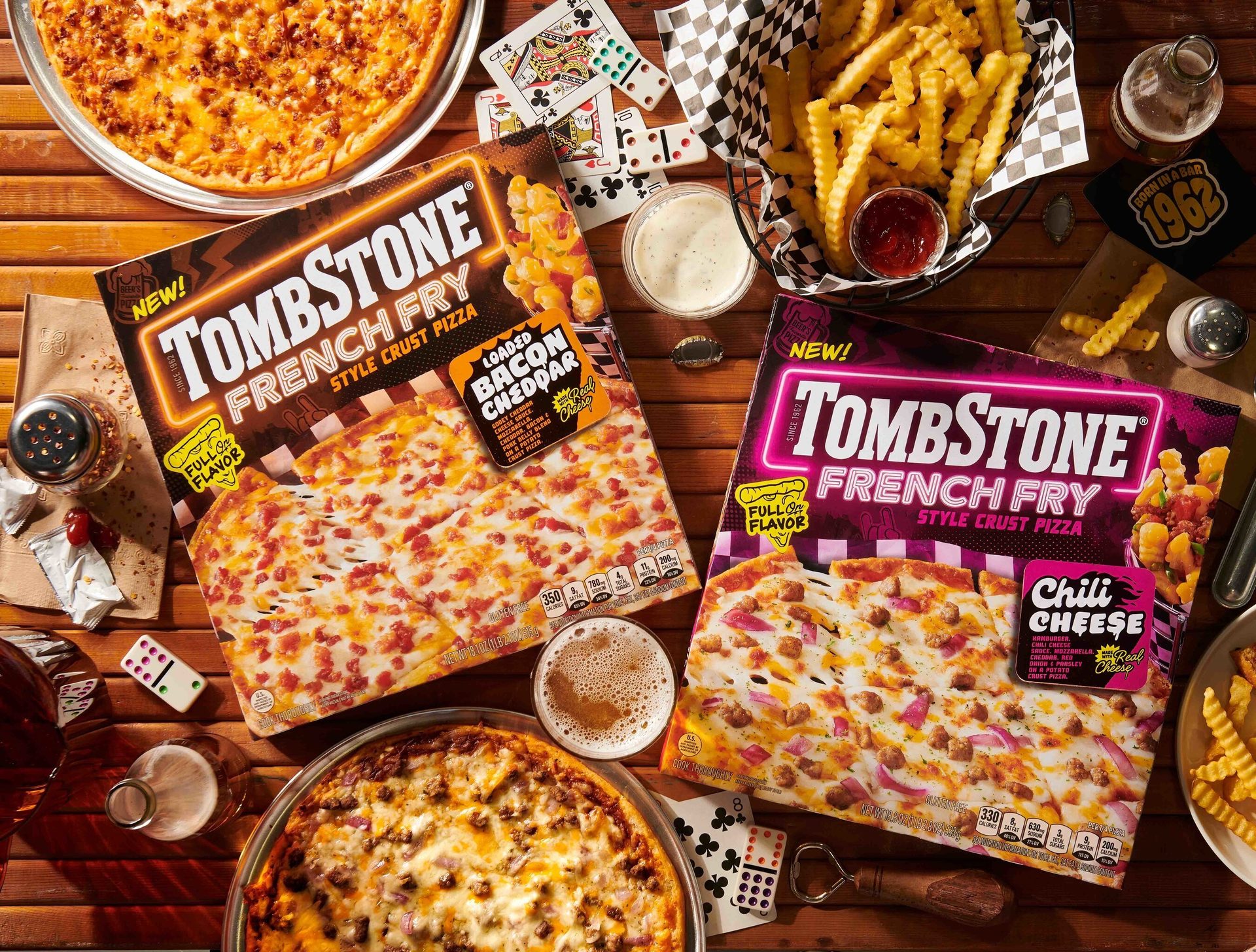 Two Tombstone French Fry Style Crust Pizza boxes (Loaded Bacon Cheddar, Chili Cheese) amidst other pizzas, fries, and drinks.