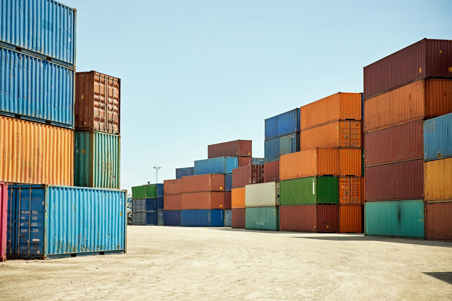 Numerous colorful shipping containers stacked high in a port.
