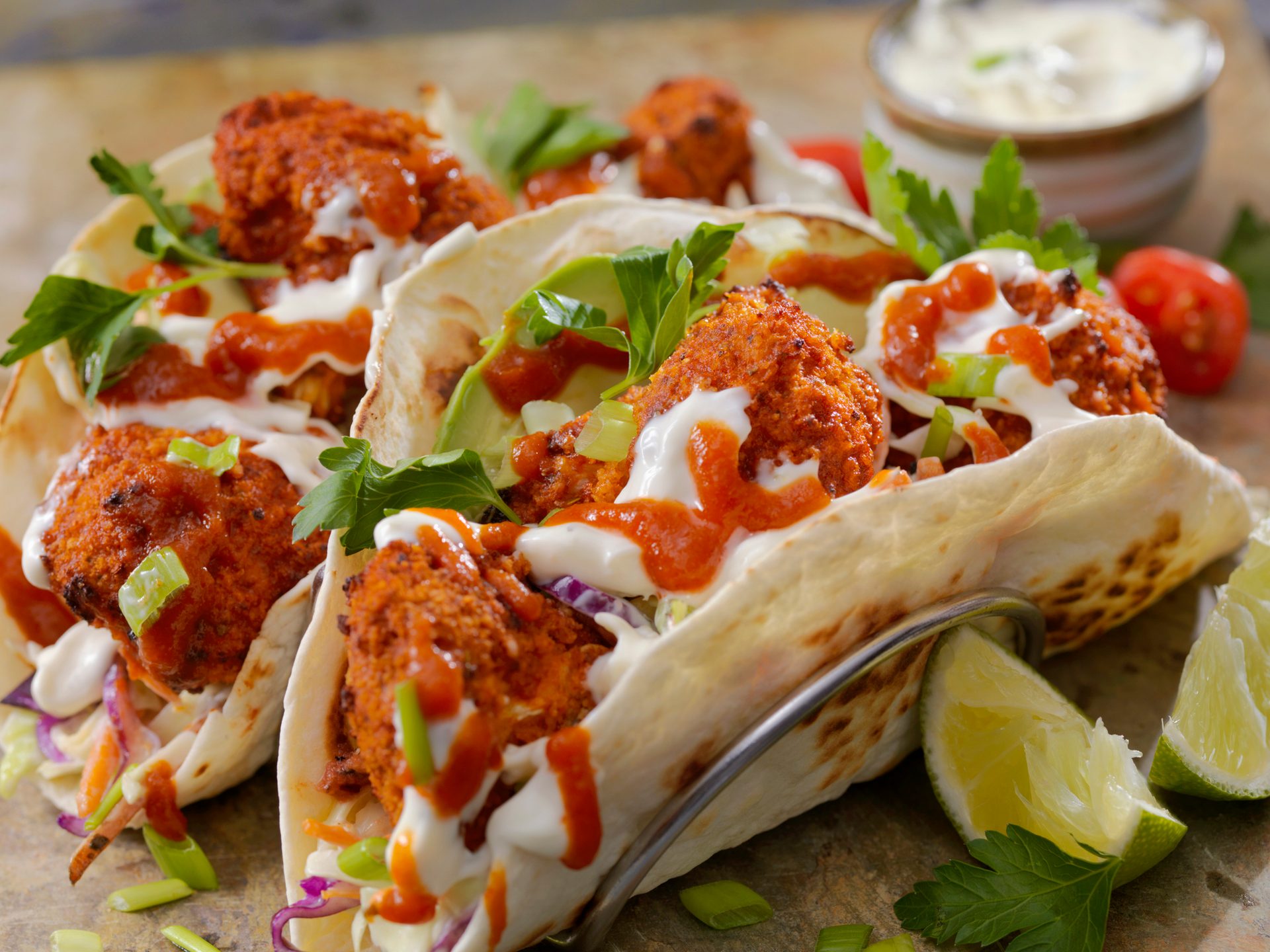 Crispy falafel tacos with creamy & spicy sauces, avocado, cabbage slaw, and fresh herbs.