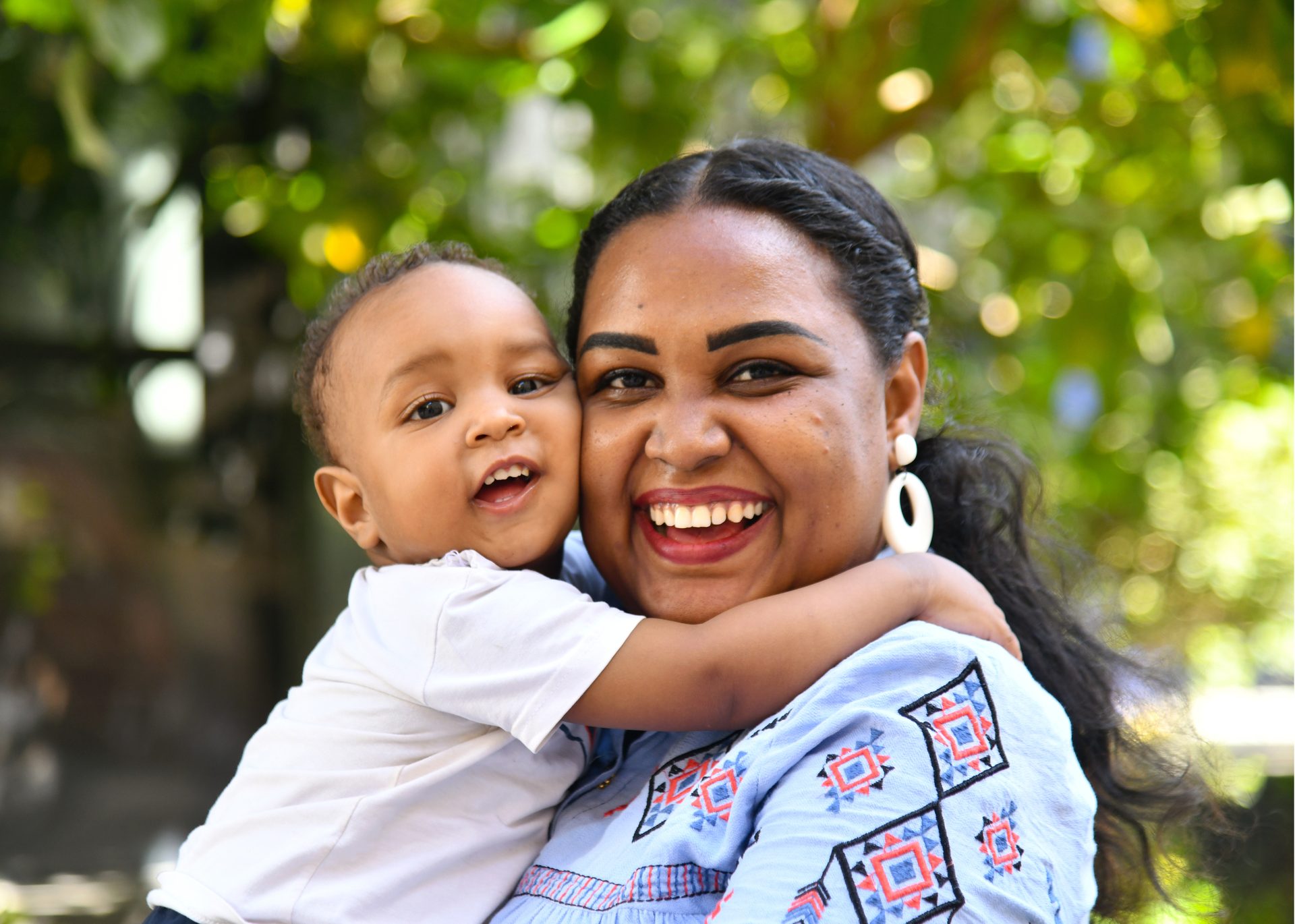 Smiling mother embracing her happy baby.