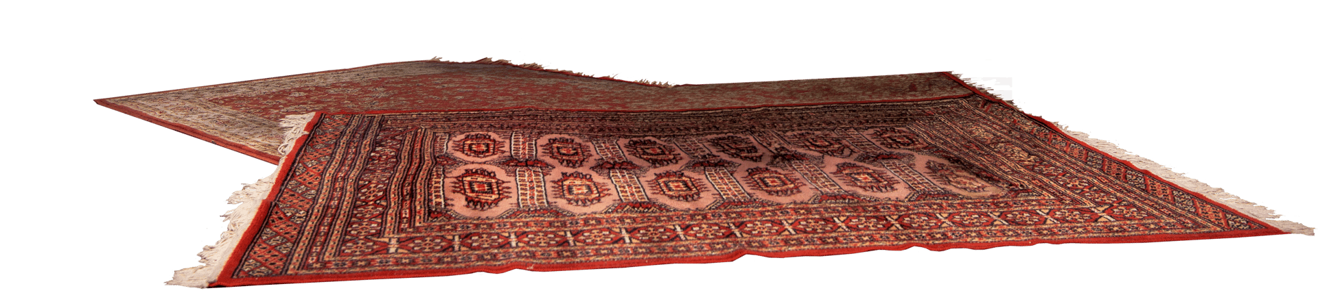 Two red, intricately patterned rugs with white fringes, partially overlapping.