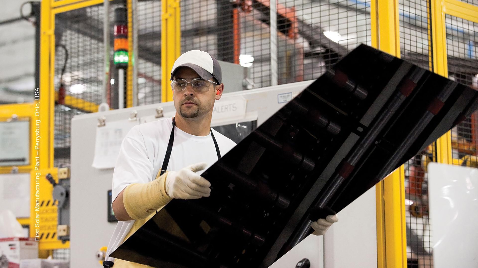 Worker at First Solar Perrysburg, Ohio plant holding a solar panel.