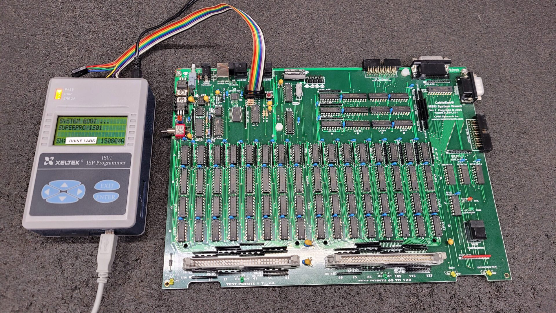 XELTEK ISP programmer connected to a CableEye M3U System Board, displaying boot status.