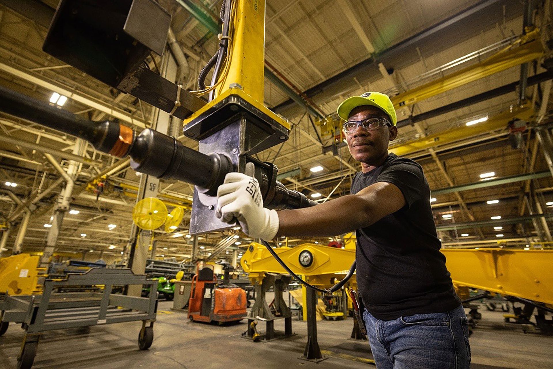 Worker in safety gear operating factory equipment.