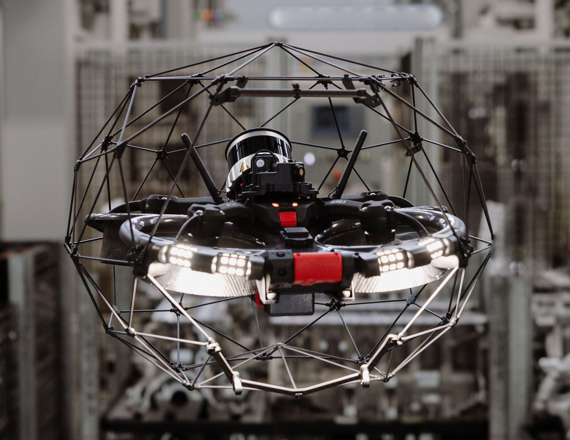 Sphere-shaped industrial inspection drone with protective cage, integrated lights, and a lidar sensor.