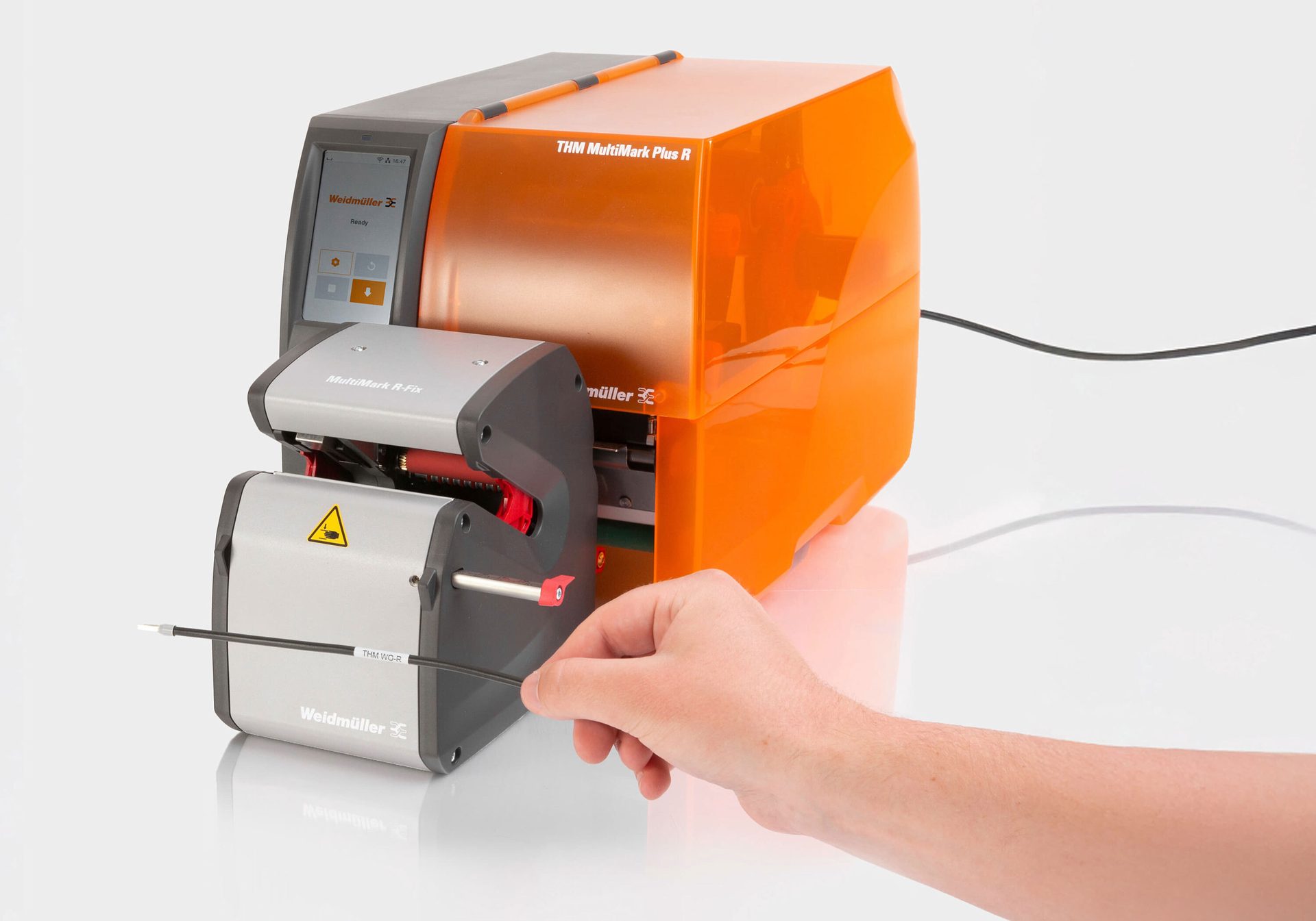 Weidmüller MultiMark printer labels a cable fed by a hand.