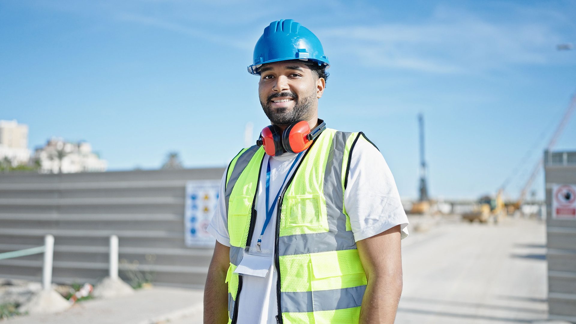High-visibility clothing, Hard hat, Helmet, Sky, Workwear, Blue, Sleeve, Jacket, Travel, Asphalt
