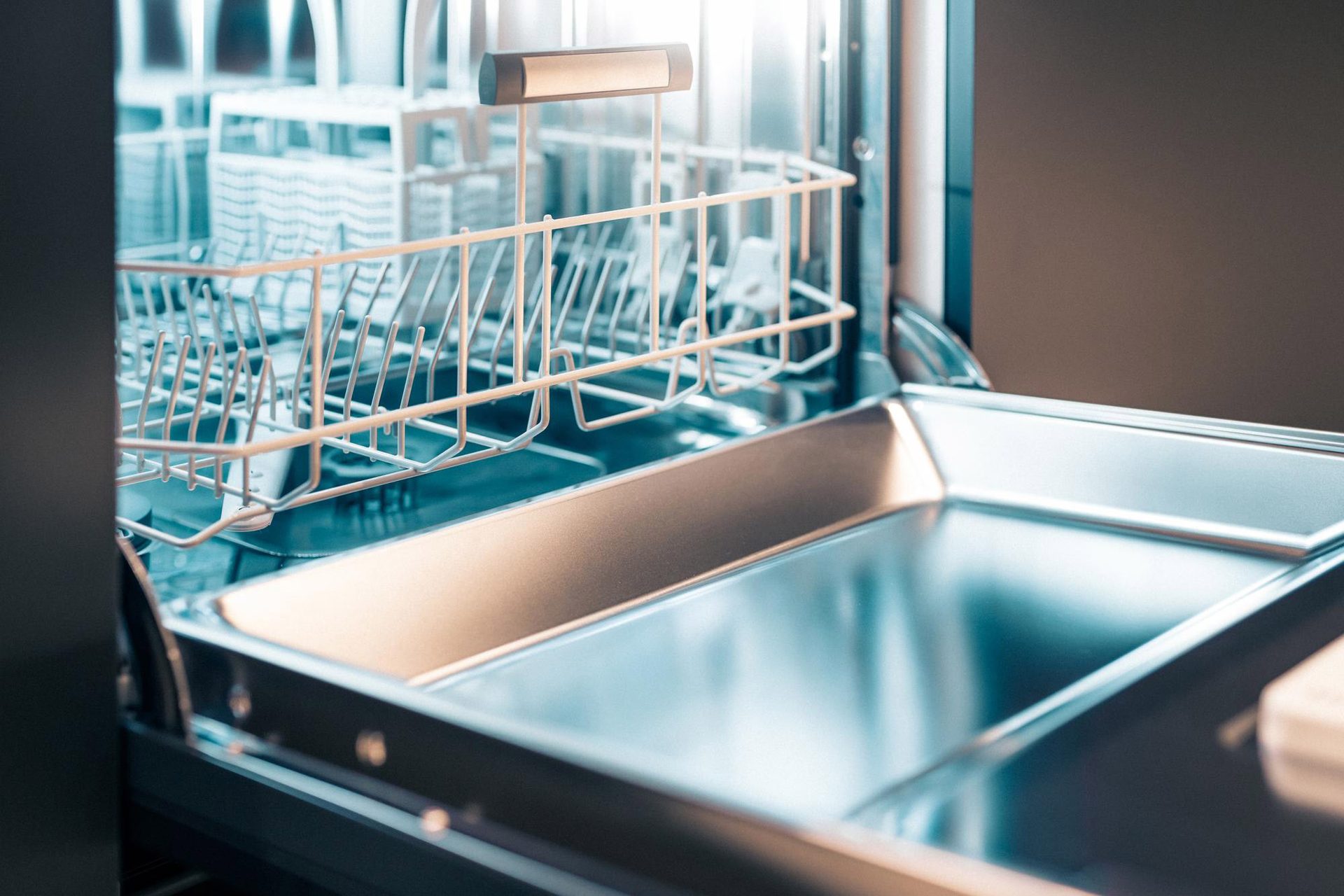 Open, empty dishwasher interior showing racks and a clean bottom tray.