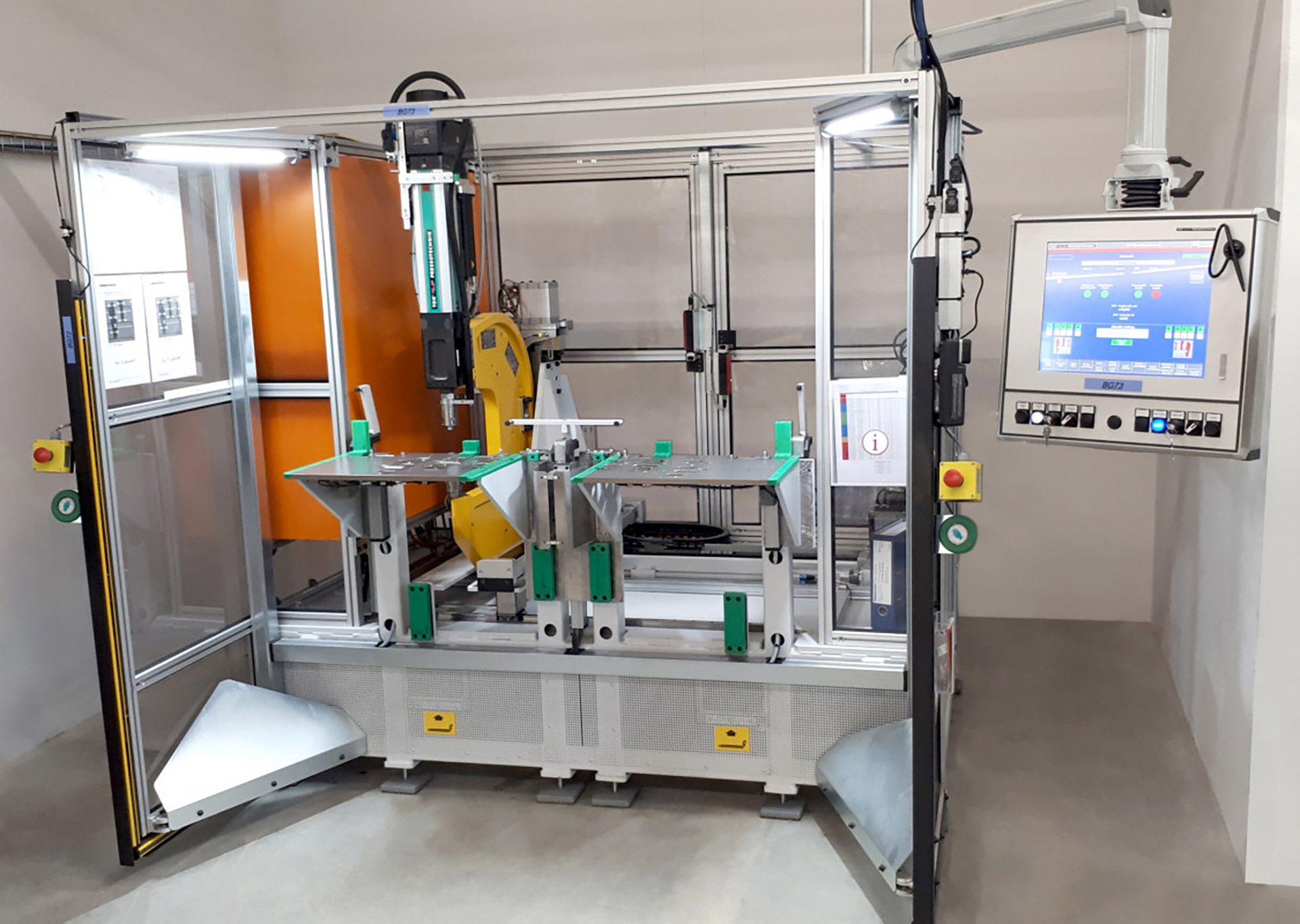 Robotic industrial automation cell with safety guarding and control screen.