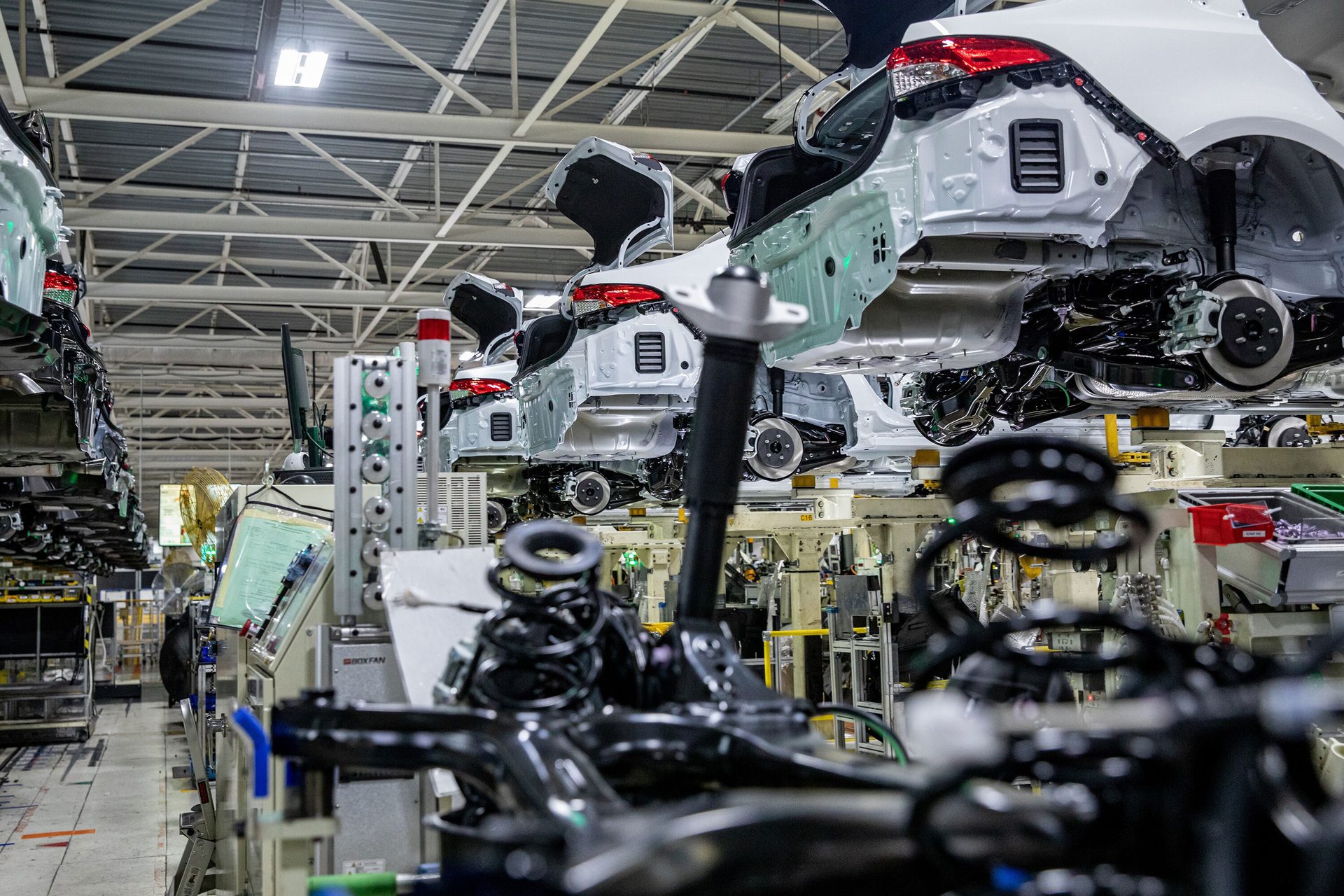 Car manufacturing factory assembly line with suspended cars.