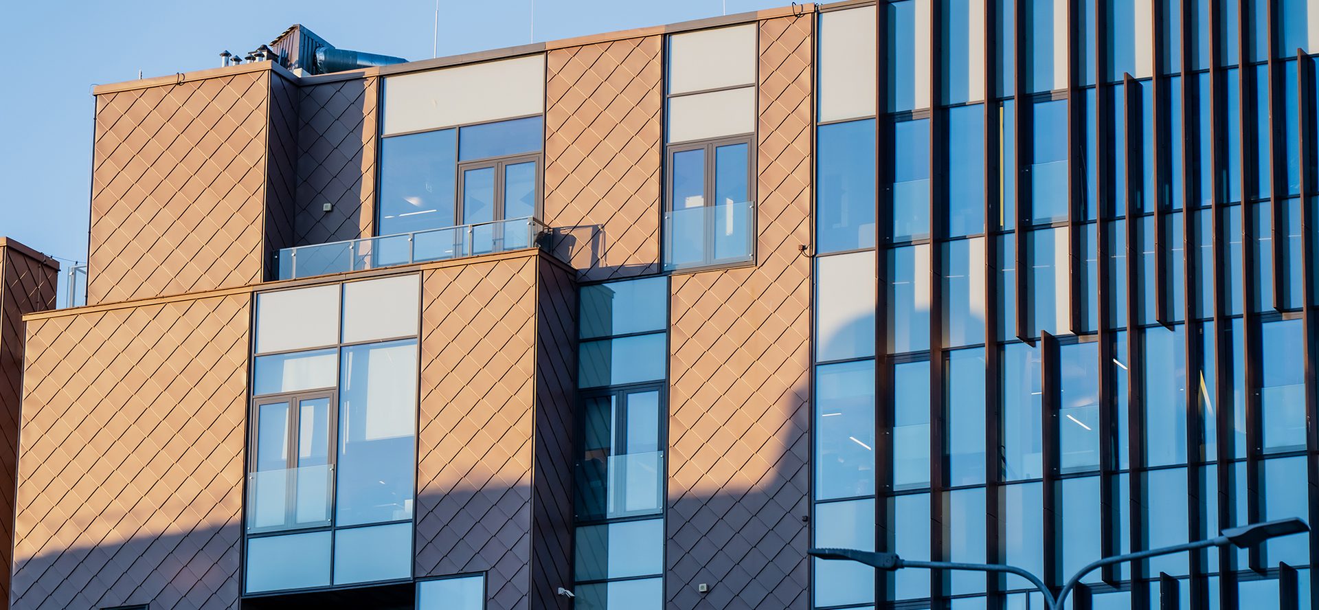 Modern commercial building facade with glass windows and patterned exterior panels, showcasing contemporary architecture, facade engineering, and urban construction industry