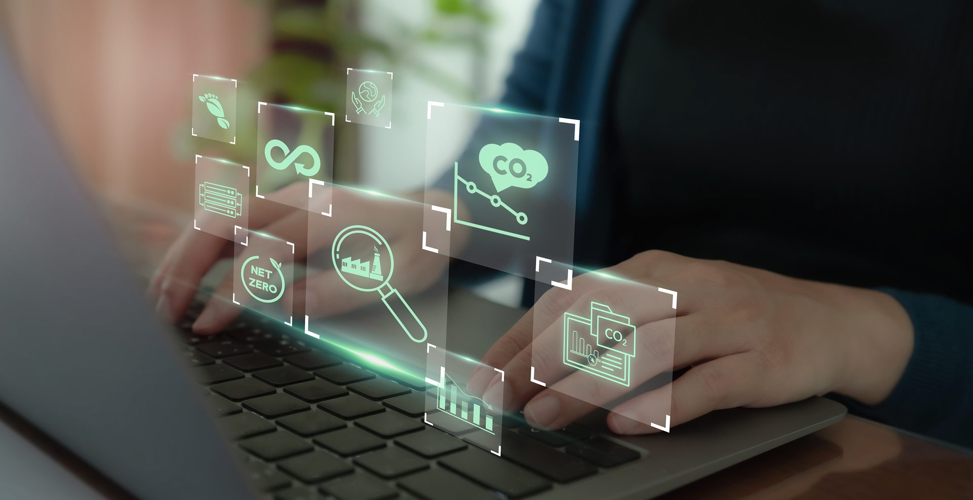 Using a laptop with digital icons representing digital tools used in measurement, reporting and verification (MRV) for environmental monitoring