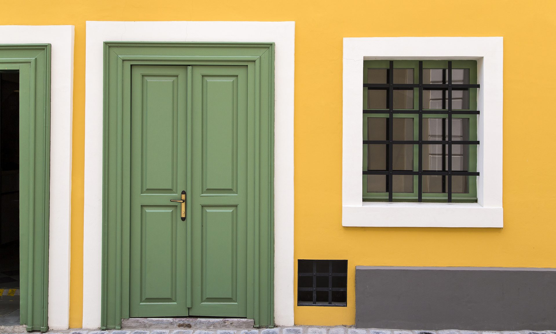 Details of a yellow house with green door and window