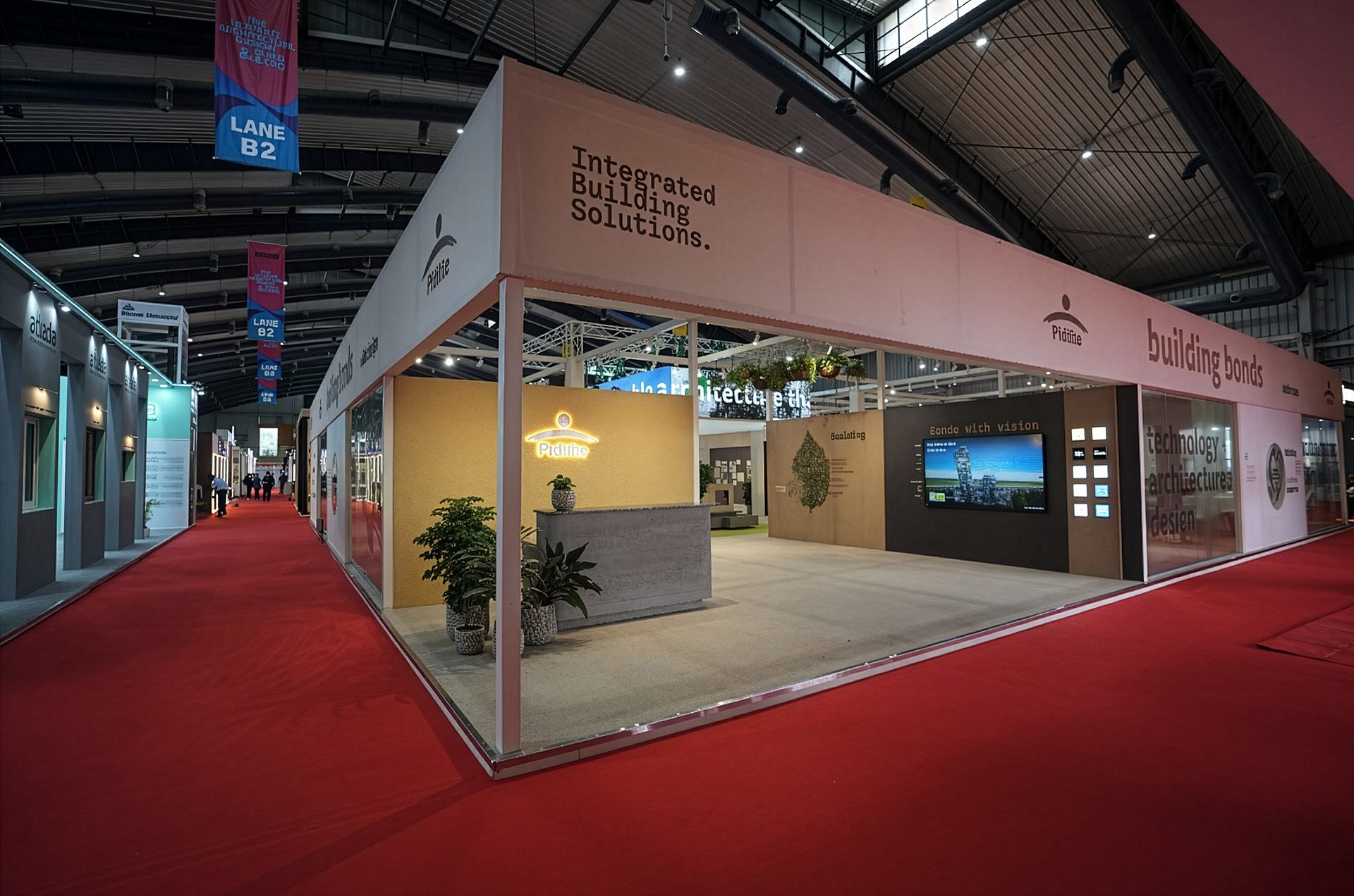 An exhibition booth for Pidilite's Integrated Building Solutions, featuring a reception, displays, and a red carpet.