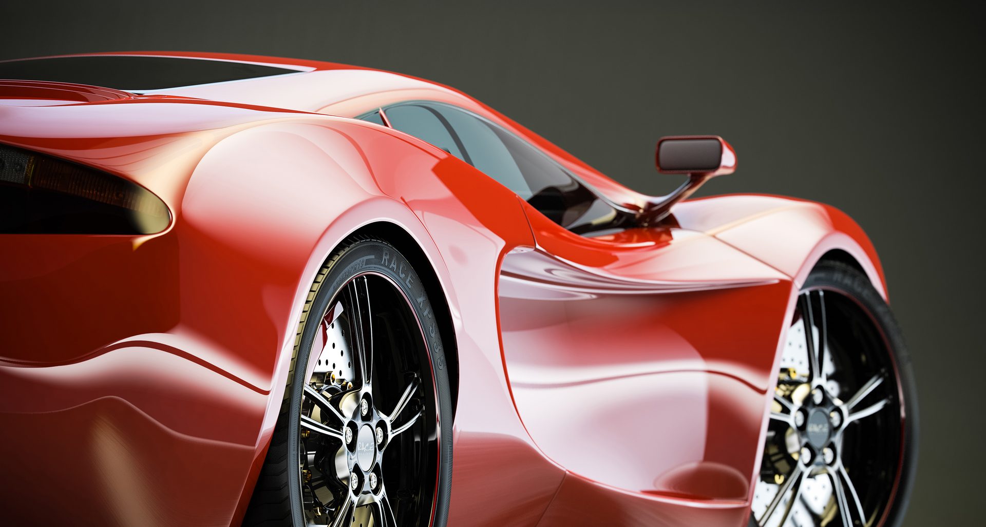 Close view of a sleek red sports car against a dark background