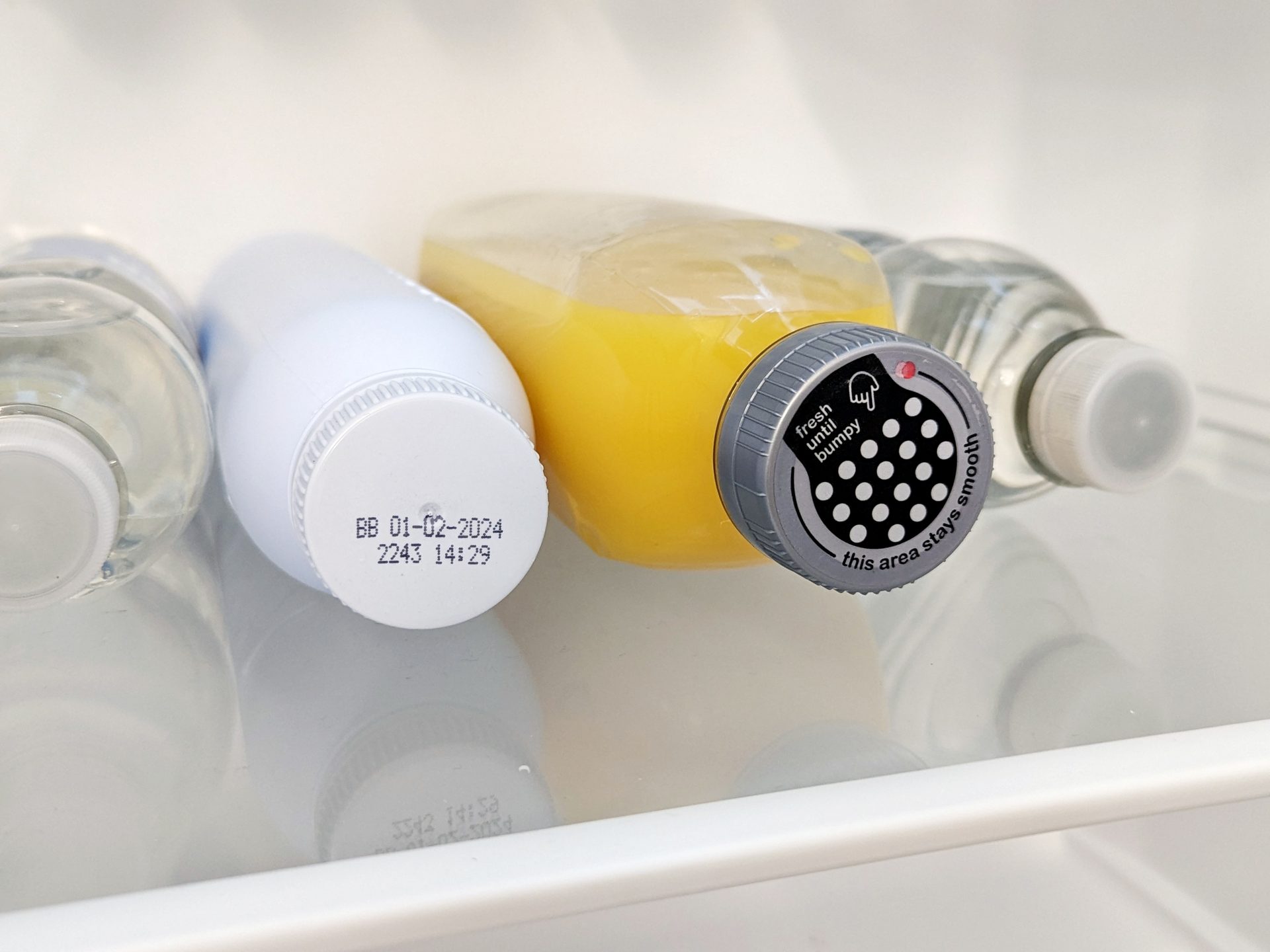 Orange juice bottle in refrigerator featuring the Bump Cap.