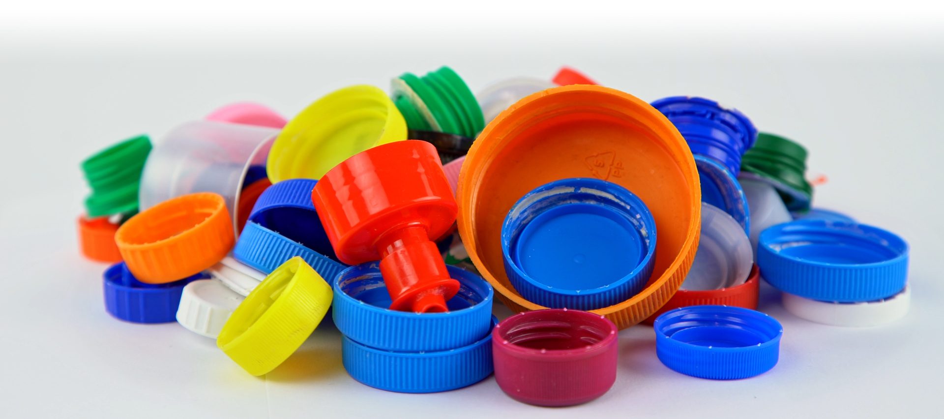 Multicolored plastic bottle caps isolated on white background