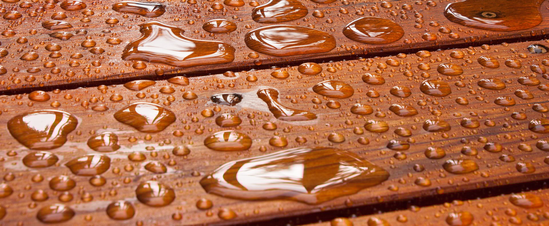 A close up on a recently sealed cottage deck just after the summer rain.