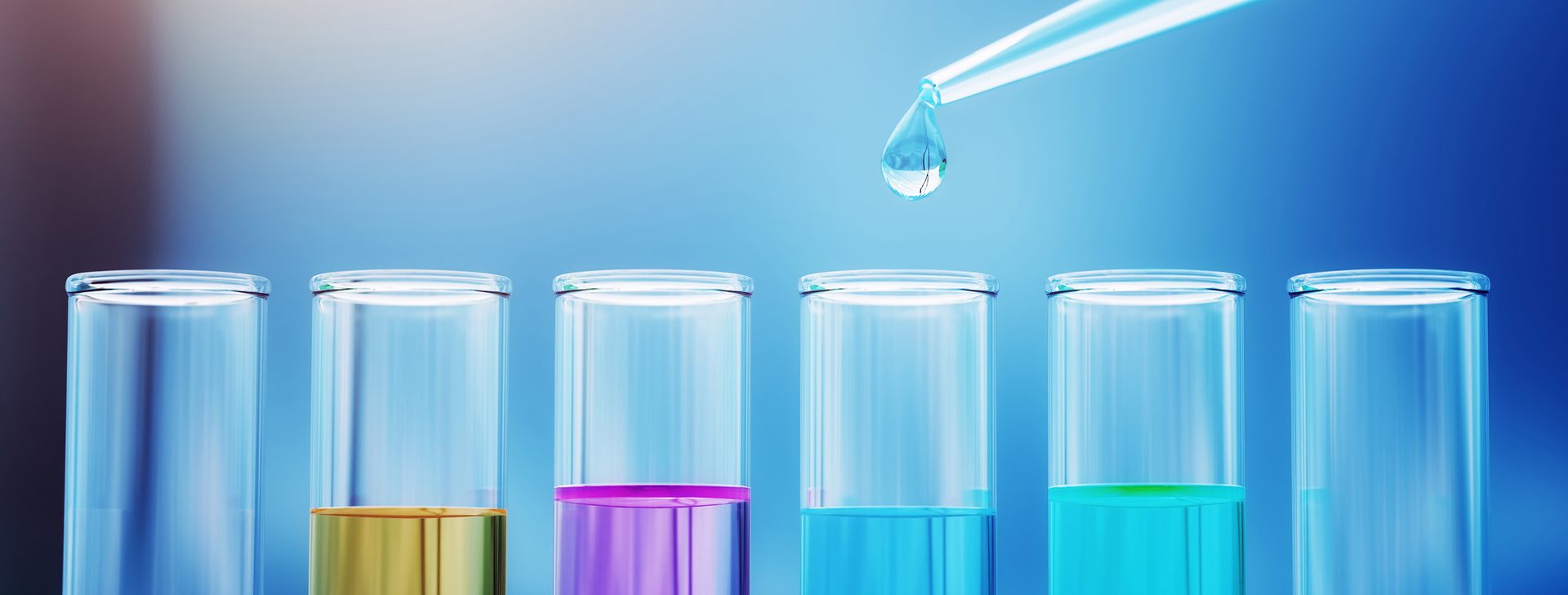 Colored Liquid Testing from Glass Pipette to Test Tubes on Blue Reflective Background