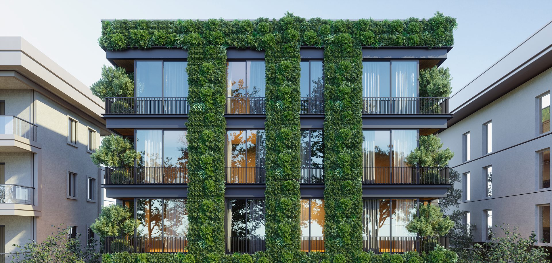 A modern building featuring extensive vertical gardens and a lush green roof, flanked by two other buildings.