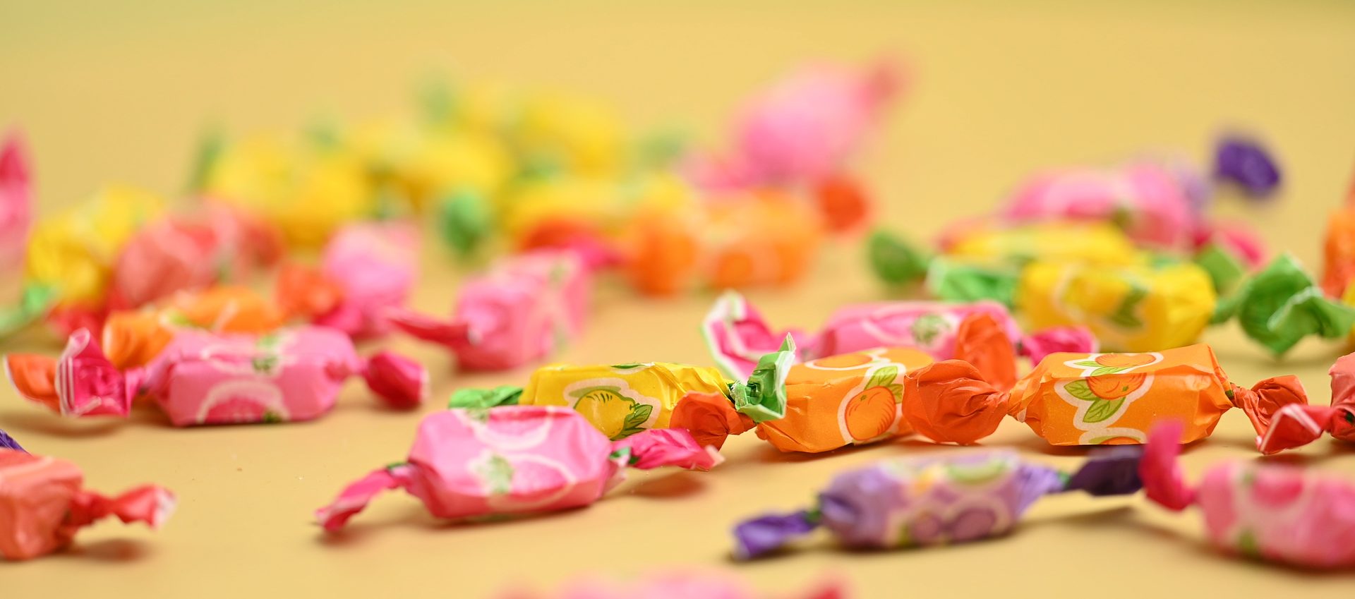 Fruit candies on yellow background