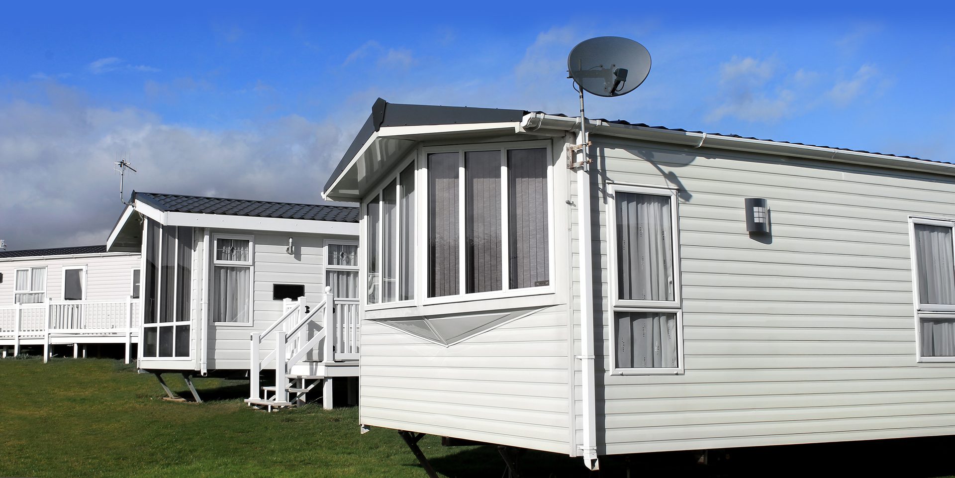 Scenic view of a manufactured home community in summer with blue sky and cloudscape background