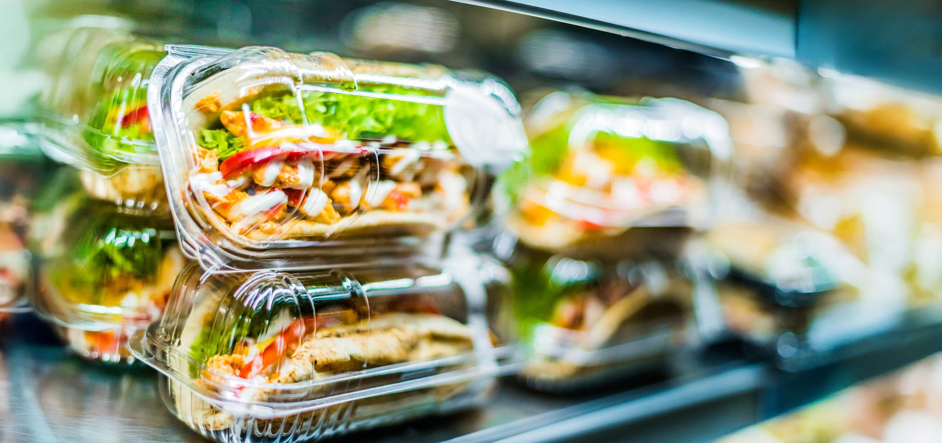 Chilli chicken with pita, pre-packaged sandwiches displayed in a commercial refrigerator