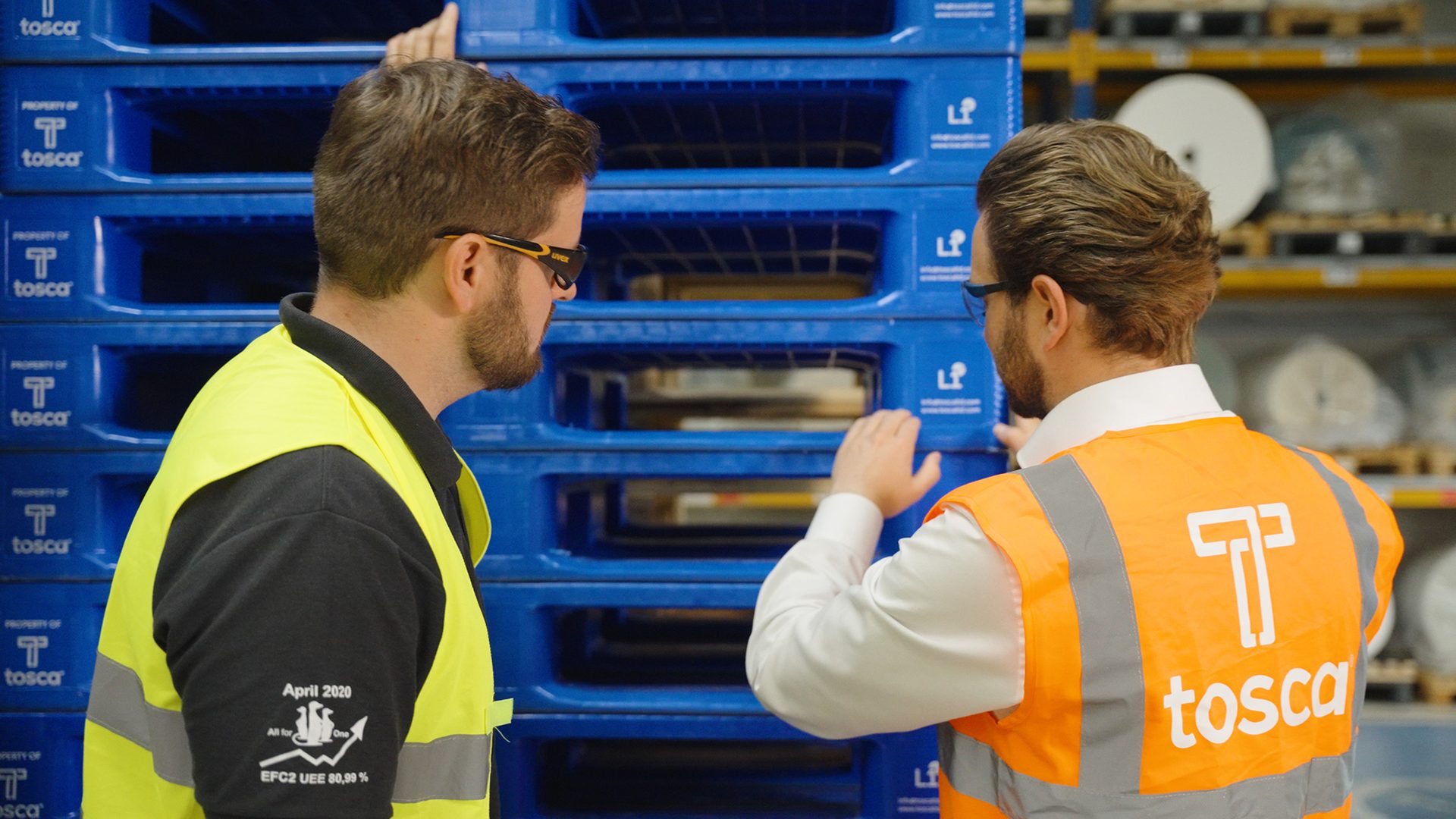 Image of an Avery Dennison employee and a Tosca employee examining reusable plastic pallets