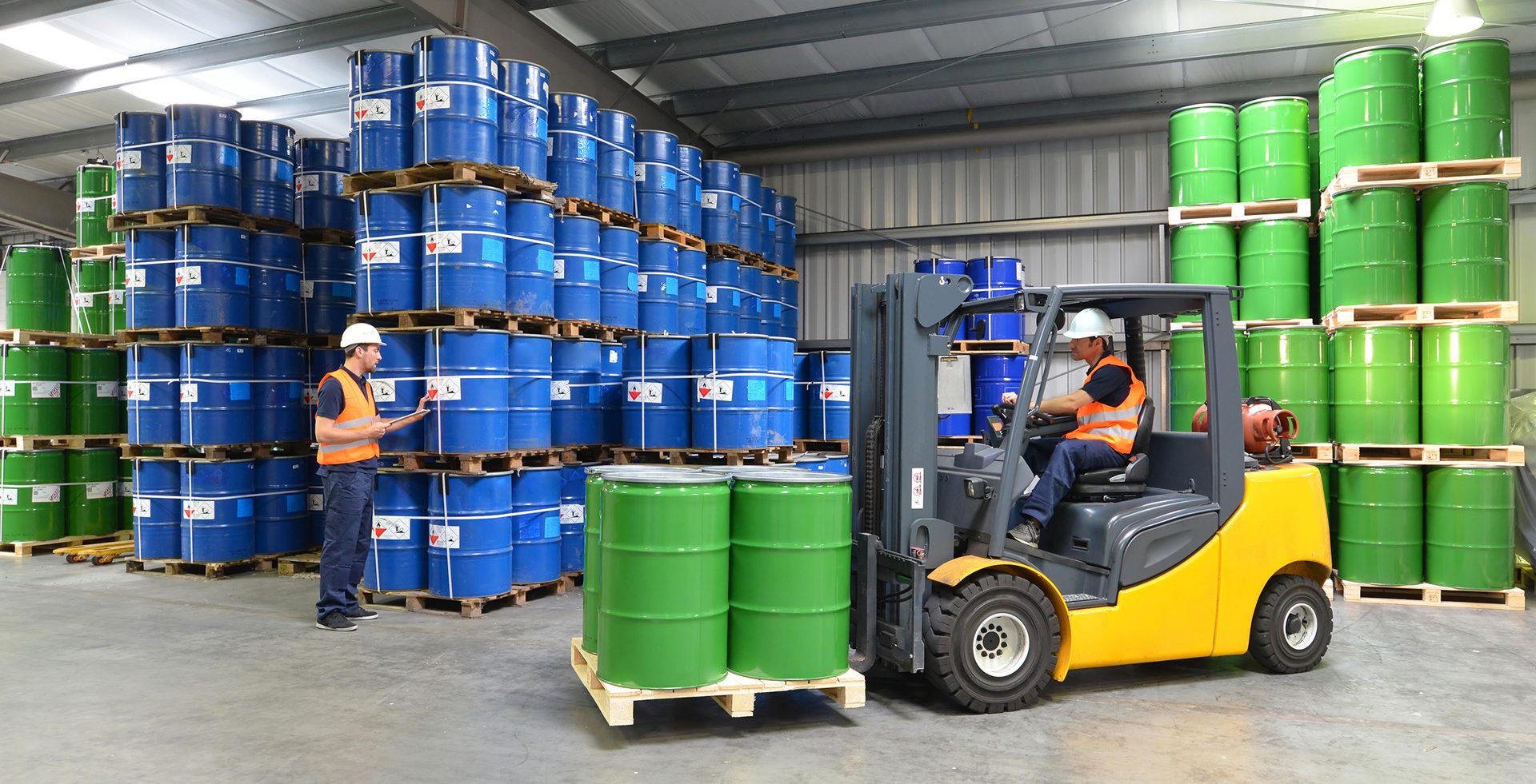 Group of workers in a warehouse with chemicals and a forklift