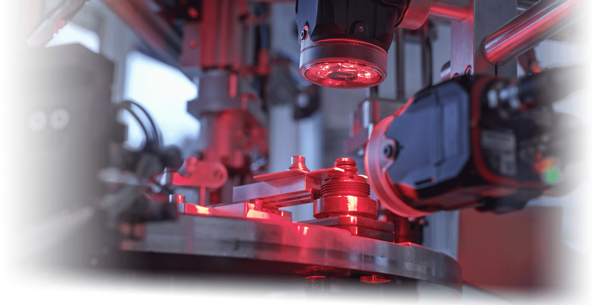 Camera with red lighting inspecting manufactured part