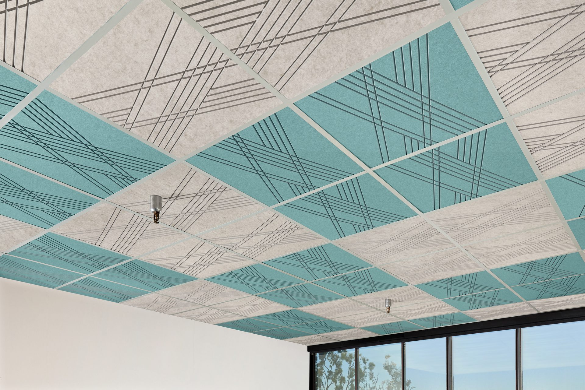 Alternating beige and teal acoustical ceiling tiles with etched diagonal line patterns, set in a grid.